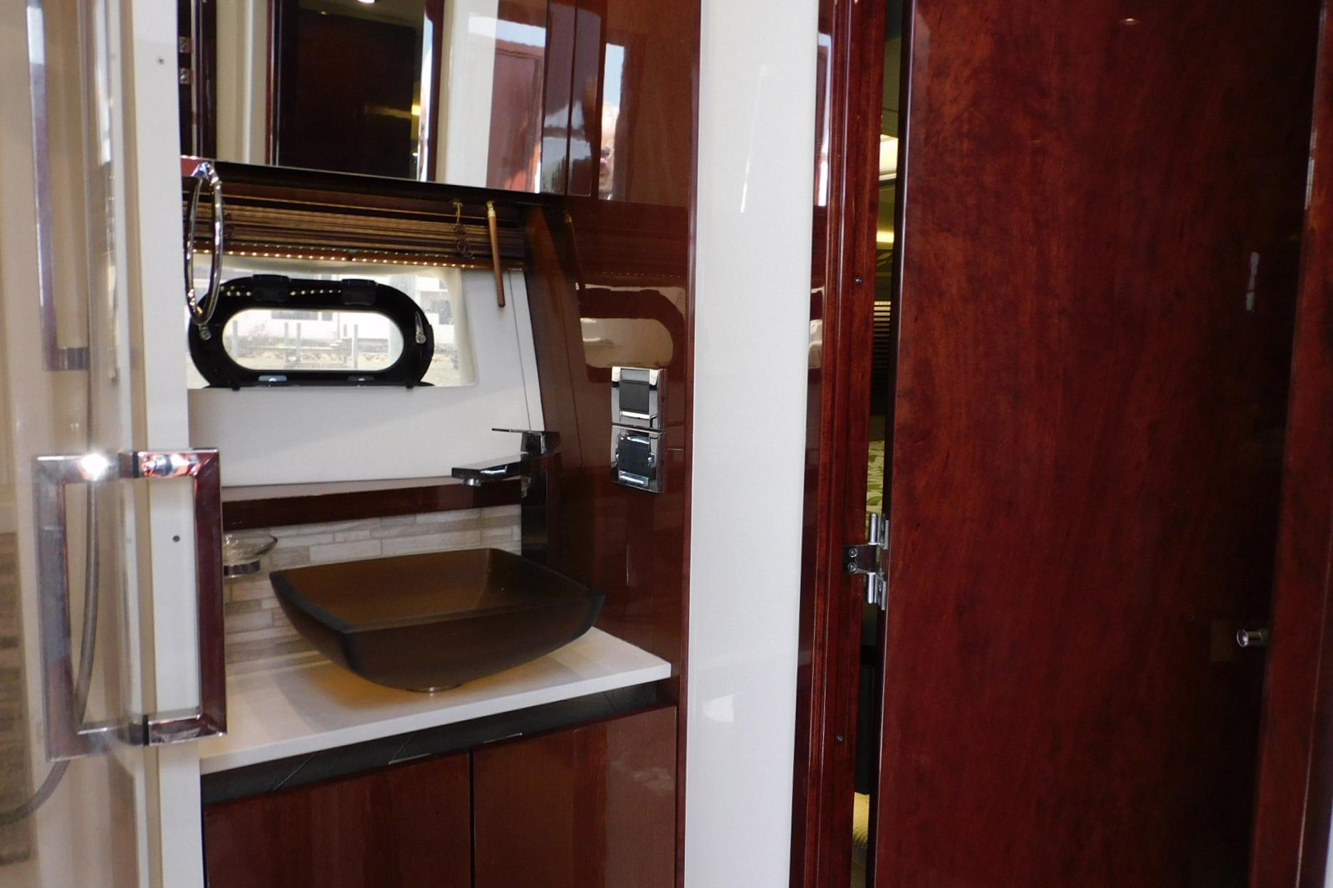 Luxurious 2019 Sea Ray L550 yacht bathroom with modern sink and elegant wood finishes.