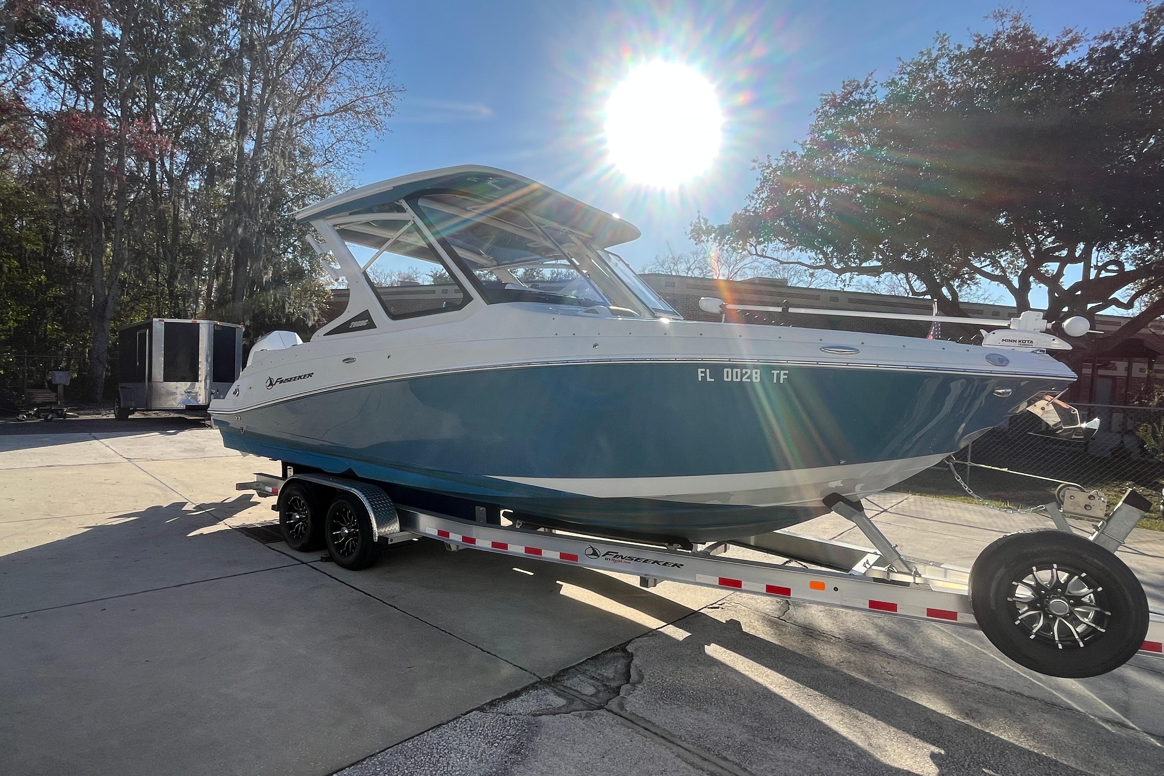 2022 Finseeker 280 DC boat on trailer under bright sunlight.
