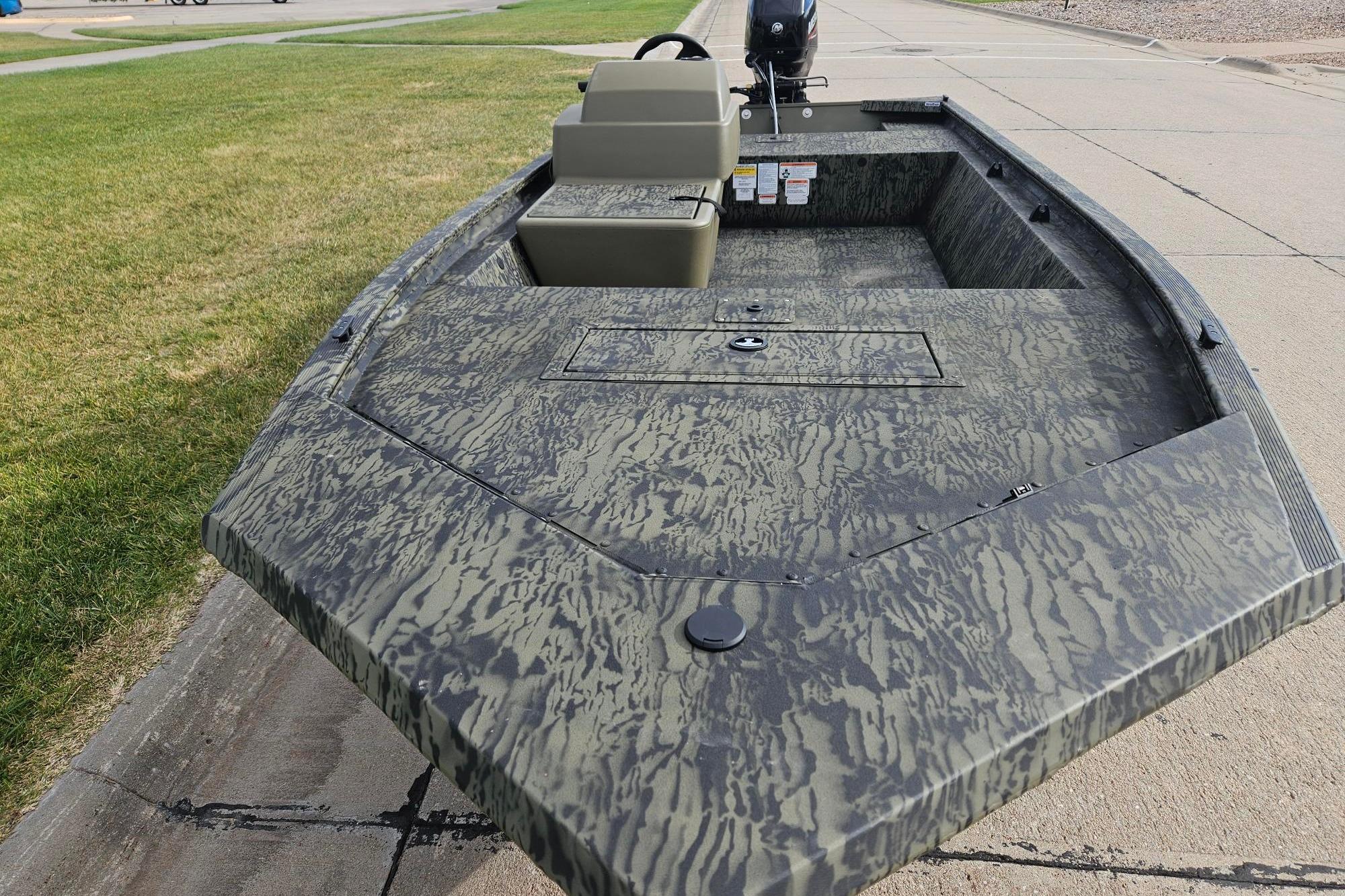 2026 Tracker Grizzly 1648 SC boat with camouflage design on pavement.