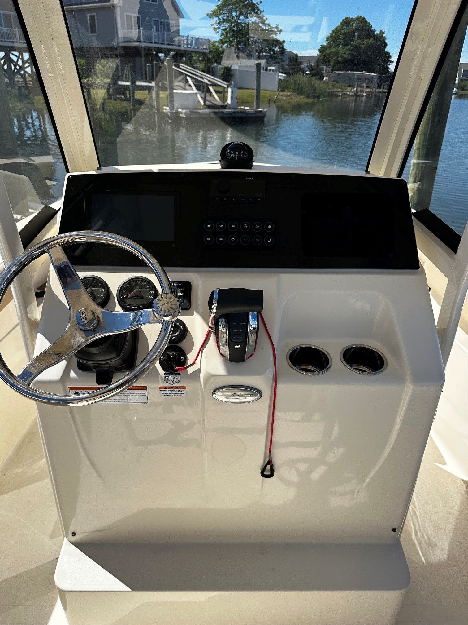 Helm console of a 2022 Scout 210XSF boat by the water.