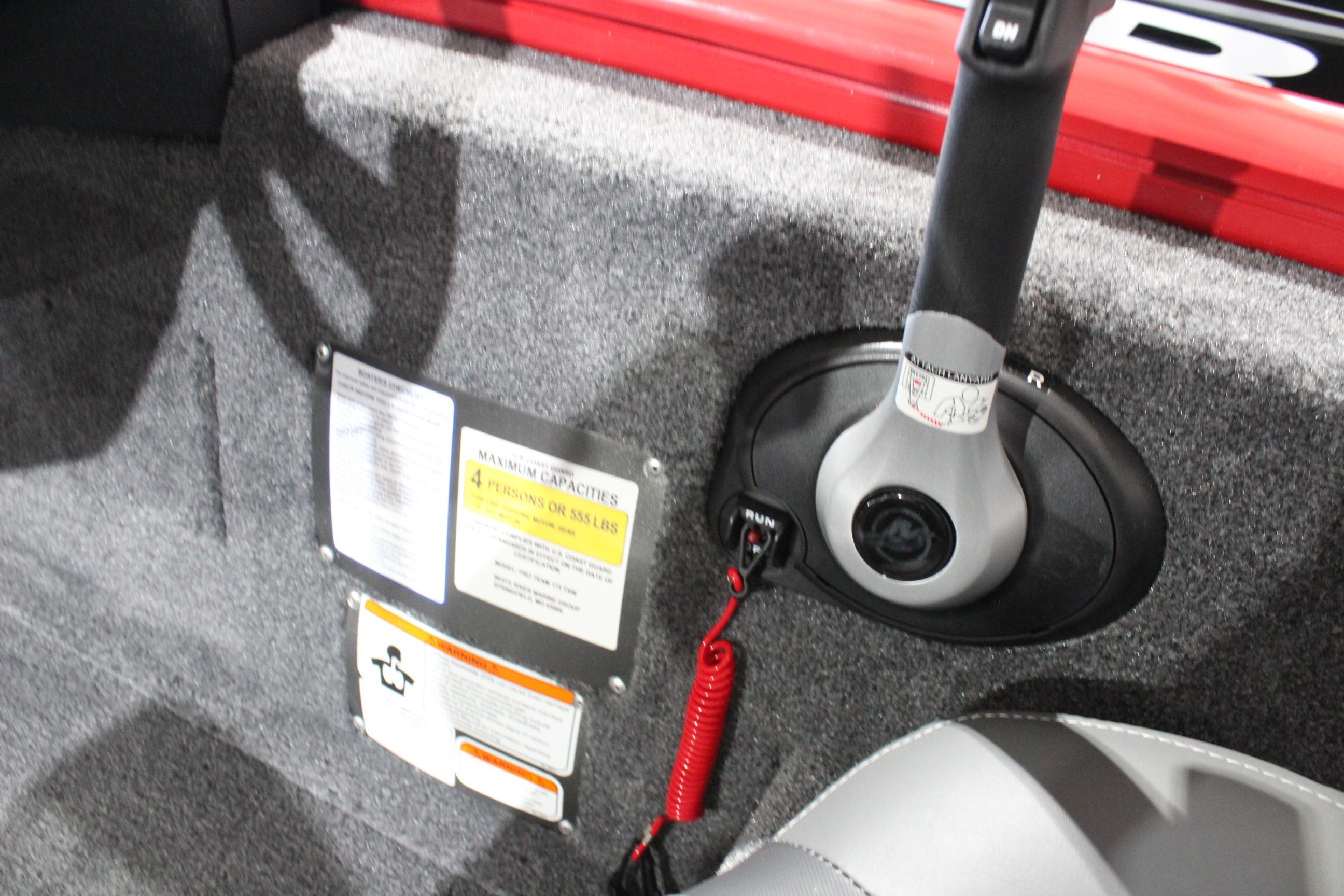 Interior of 2026 Tracker Pro Team 175 boat showing control panel and safety labels.