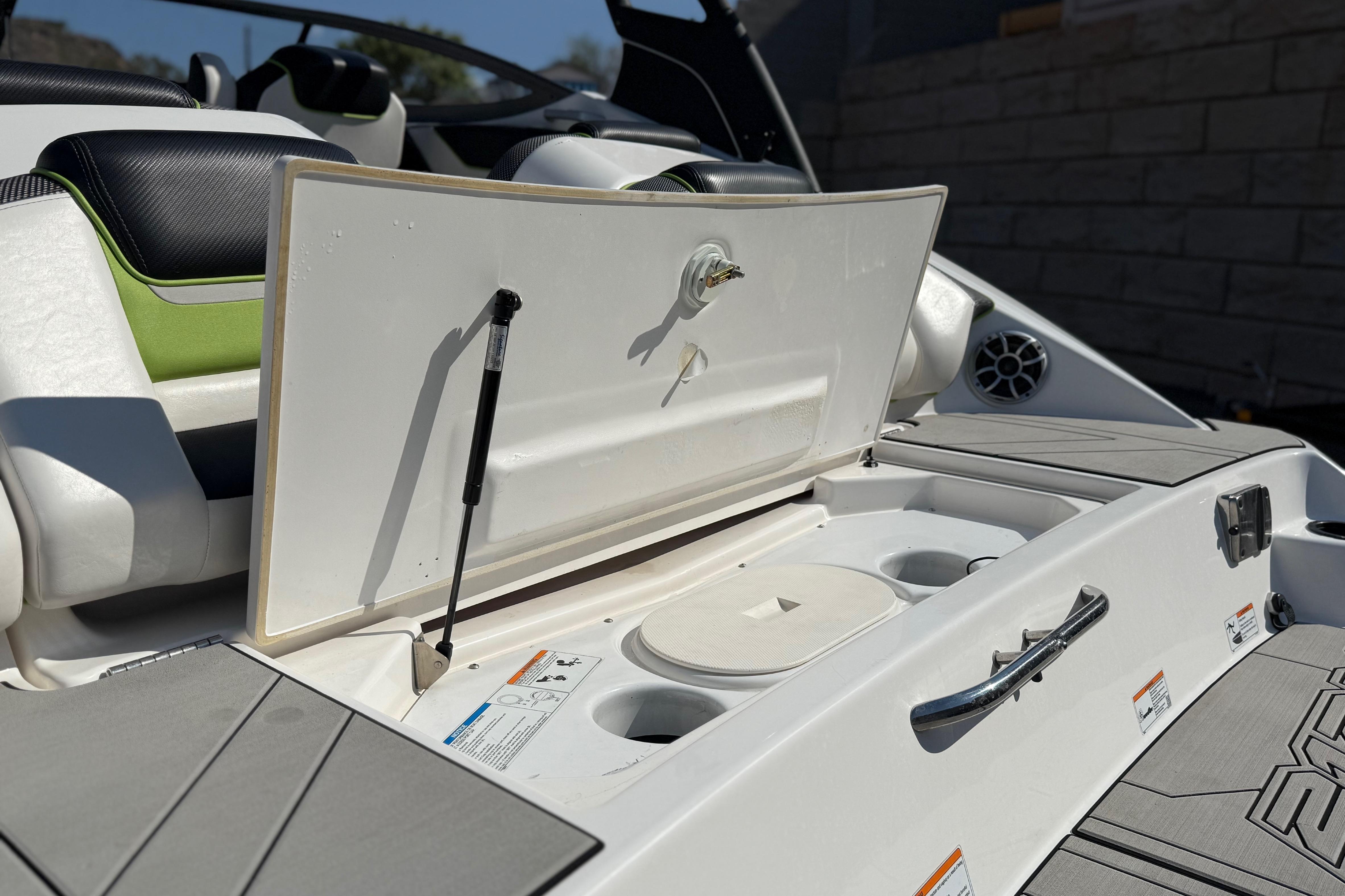 2022 Yamaha Boats 212XE storage compartment with open lid and cup holders.