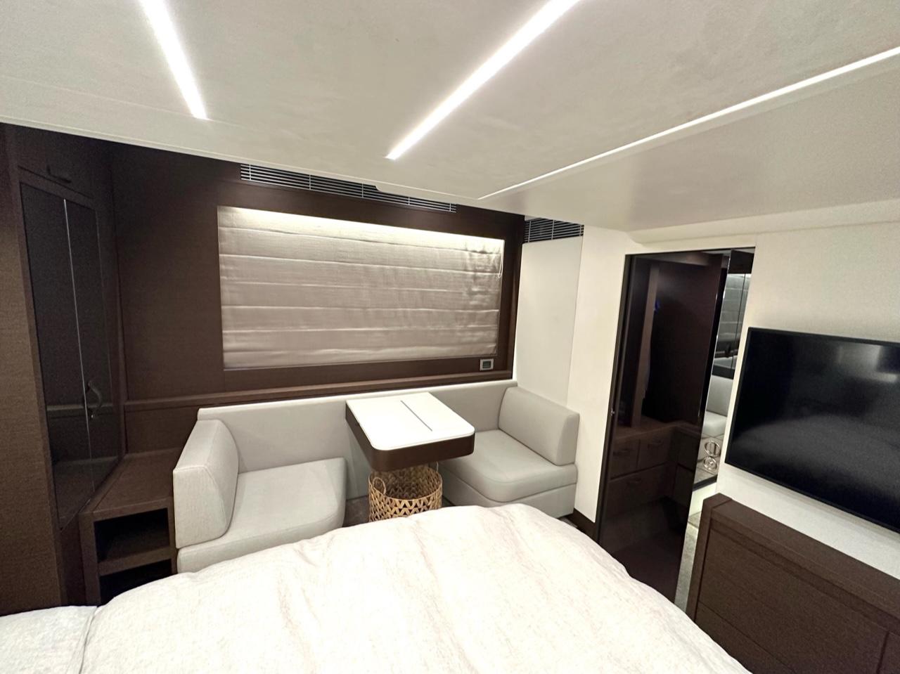 Luxurious interior of 2021 Prestige 590 Sport Fly yacht with modern seating and TV.