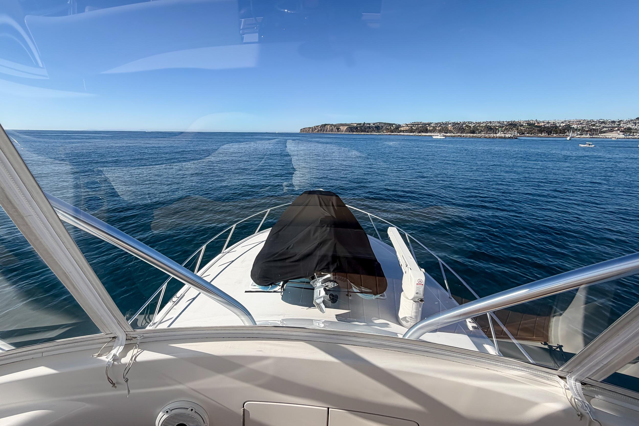 View from 2013 Viking 46 Convertible yacht, overlooking calm ocean and distant coastline.