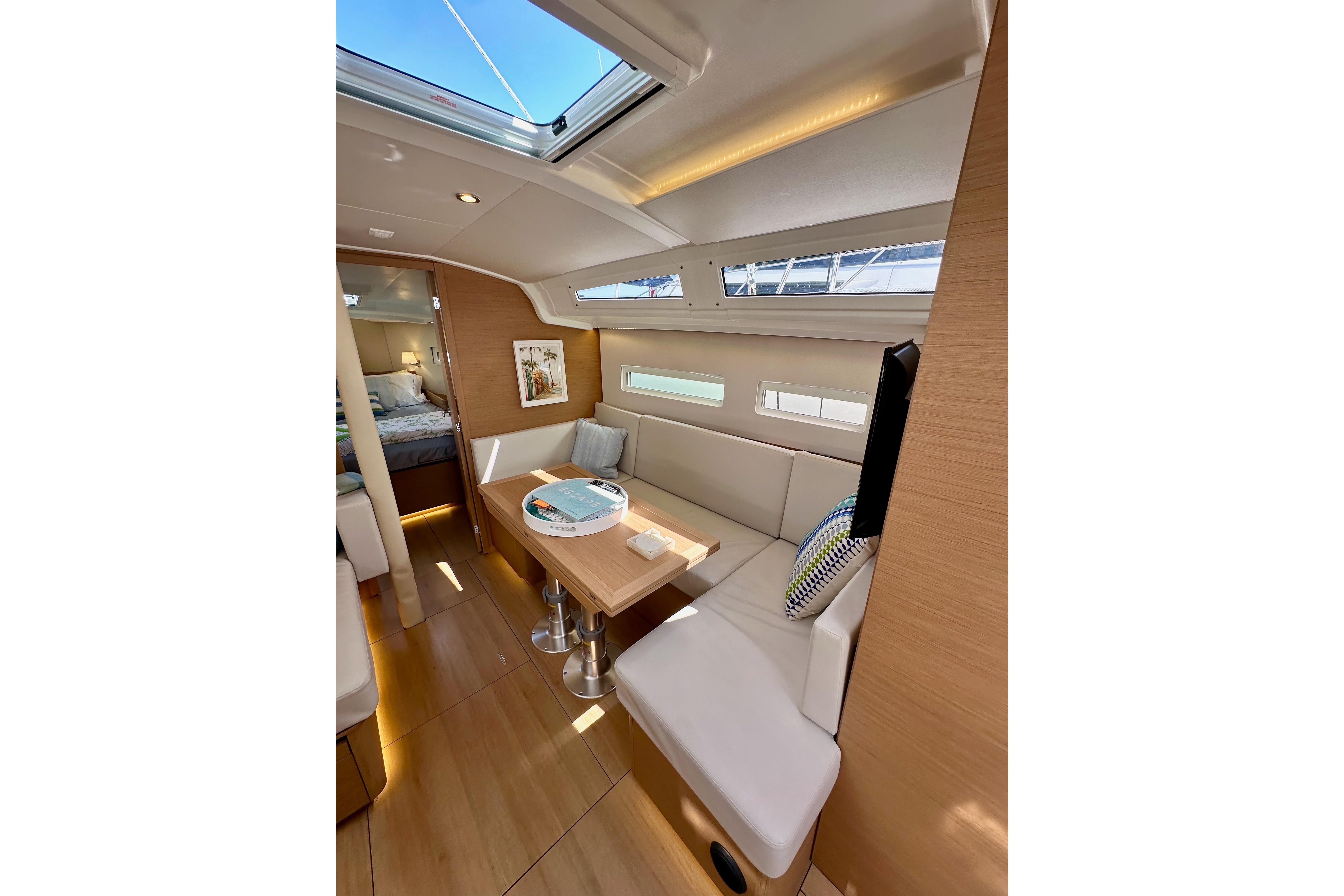 Interior of 2024 Jeanneau Sun Odyssey 410 yacht, featuring modern seating and natural light.