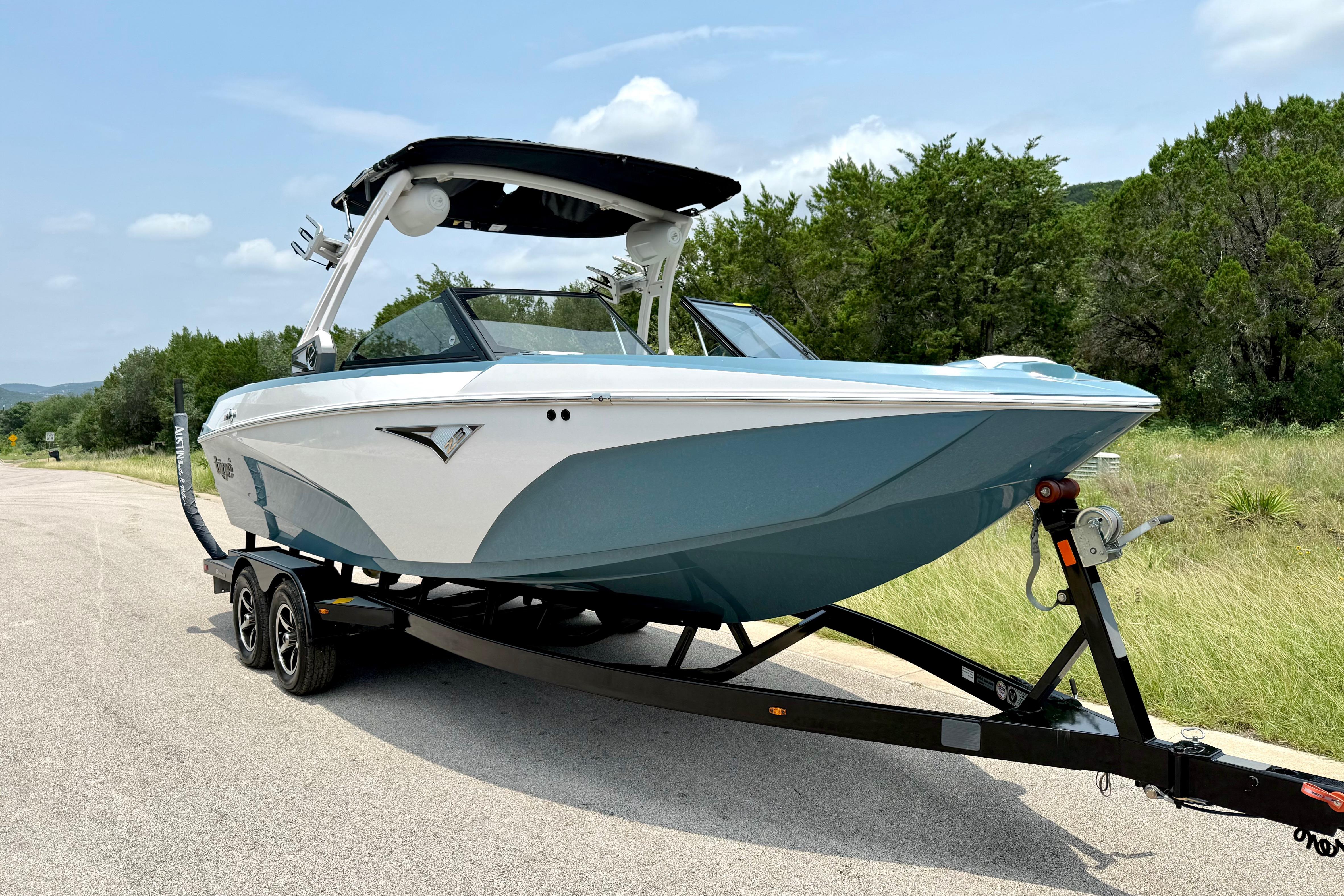 2021 Tige Z3 boat on trailer, parked on a scenic road with trees.