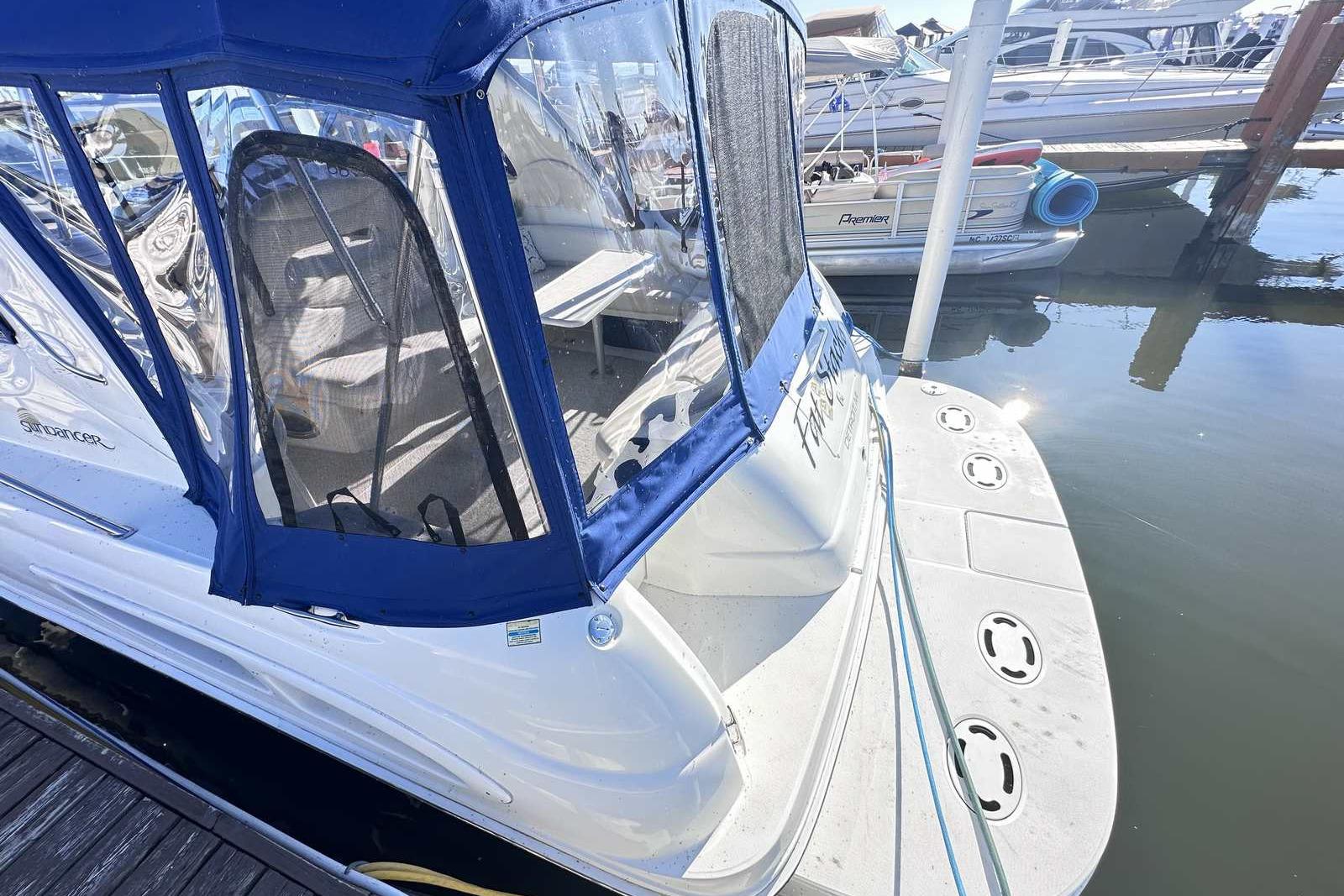 2000 Sea Ray 410 Sundancer docked, featuring blue canopy and spacious deck.