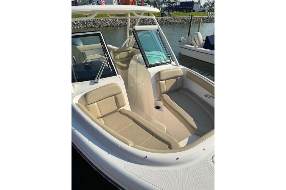 2015 Pursuit DC 265 Dual Console boat with beige seating, docked by the water.