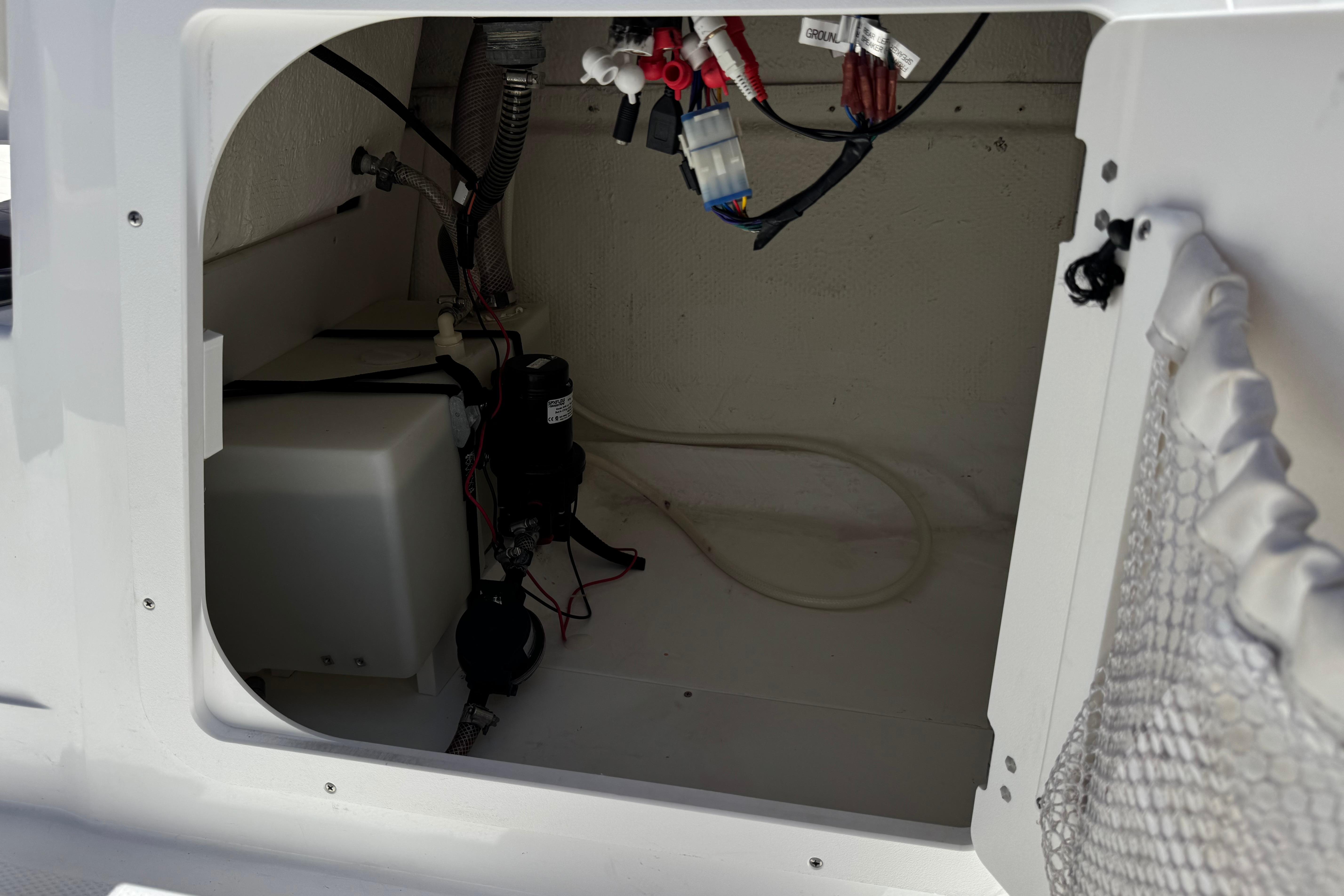 2017 Tahoe 2150 boat storage compartment with wiring and equipment.