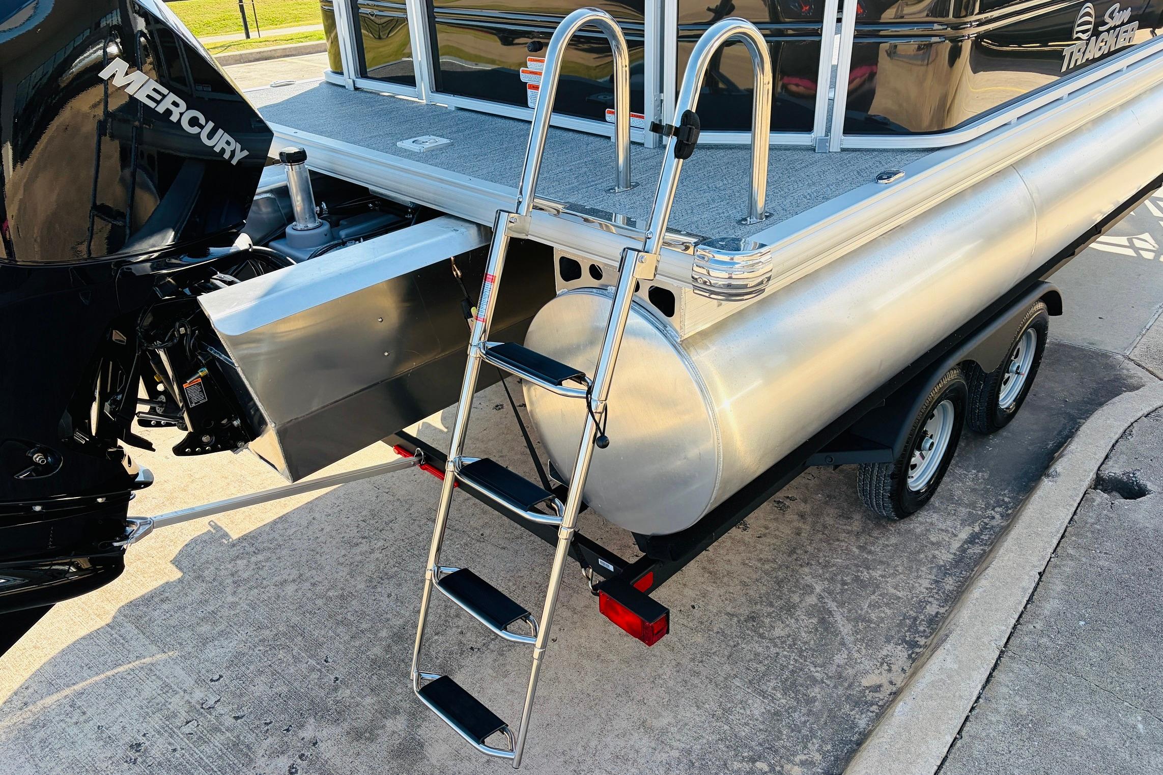 2026 Sun Tracker Fishin' Barge 22 XP3 with Mercury engine and ladder on trailer.
