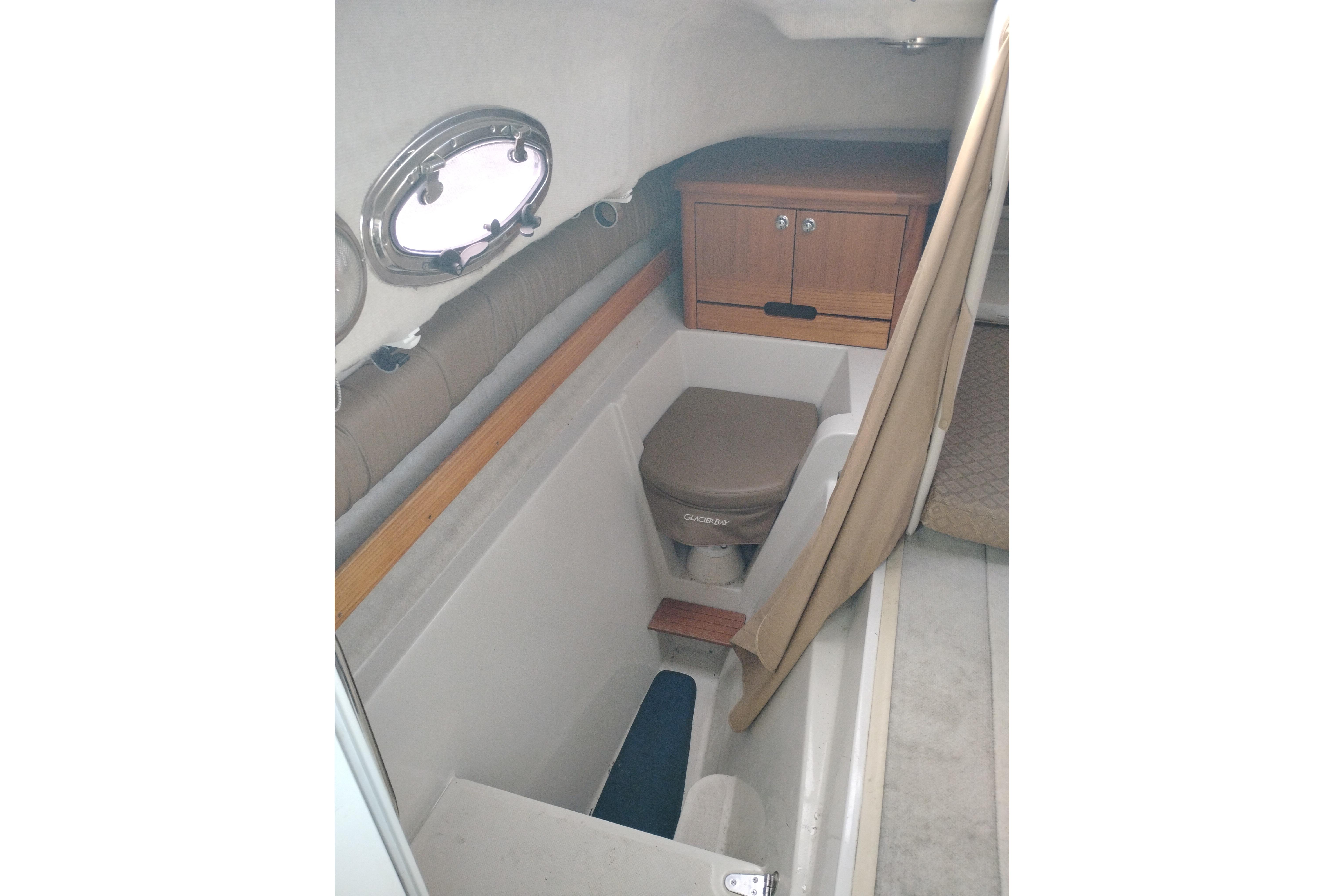 2007 Glacier Bay 2685 Coastal Runner cabin interior with compact toilet and storage.