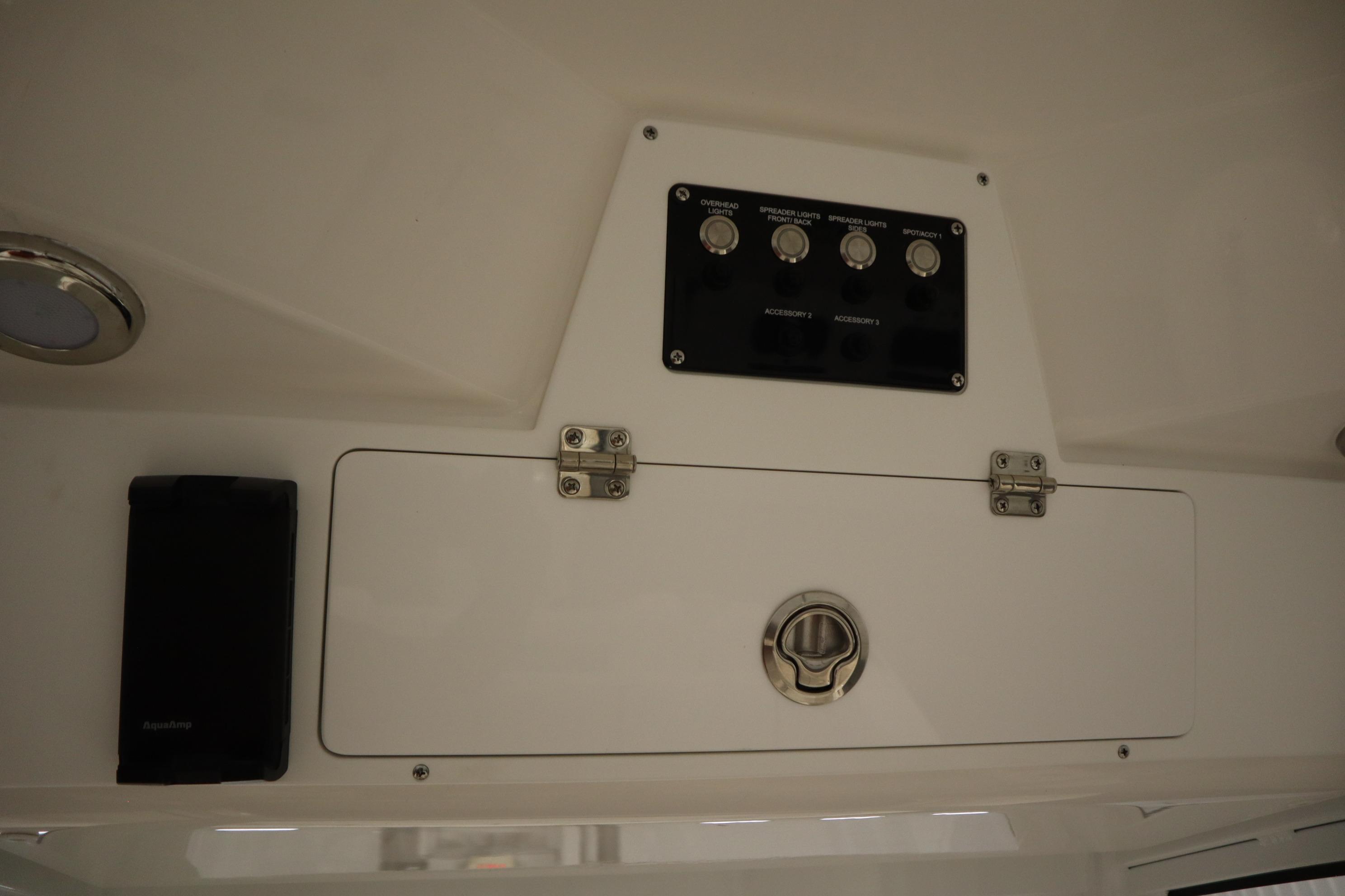 2026 Sea Fox 228 Commander control panel with switches and storage compartment.