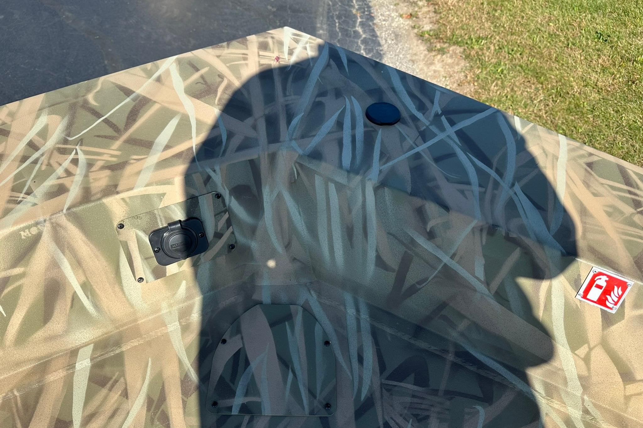 Camouflage pattern on Lowe Roughneck 2070CC boat, 2026 model, with shadow and fire extinguisher label.
