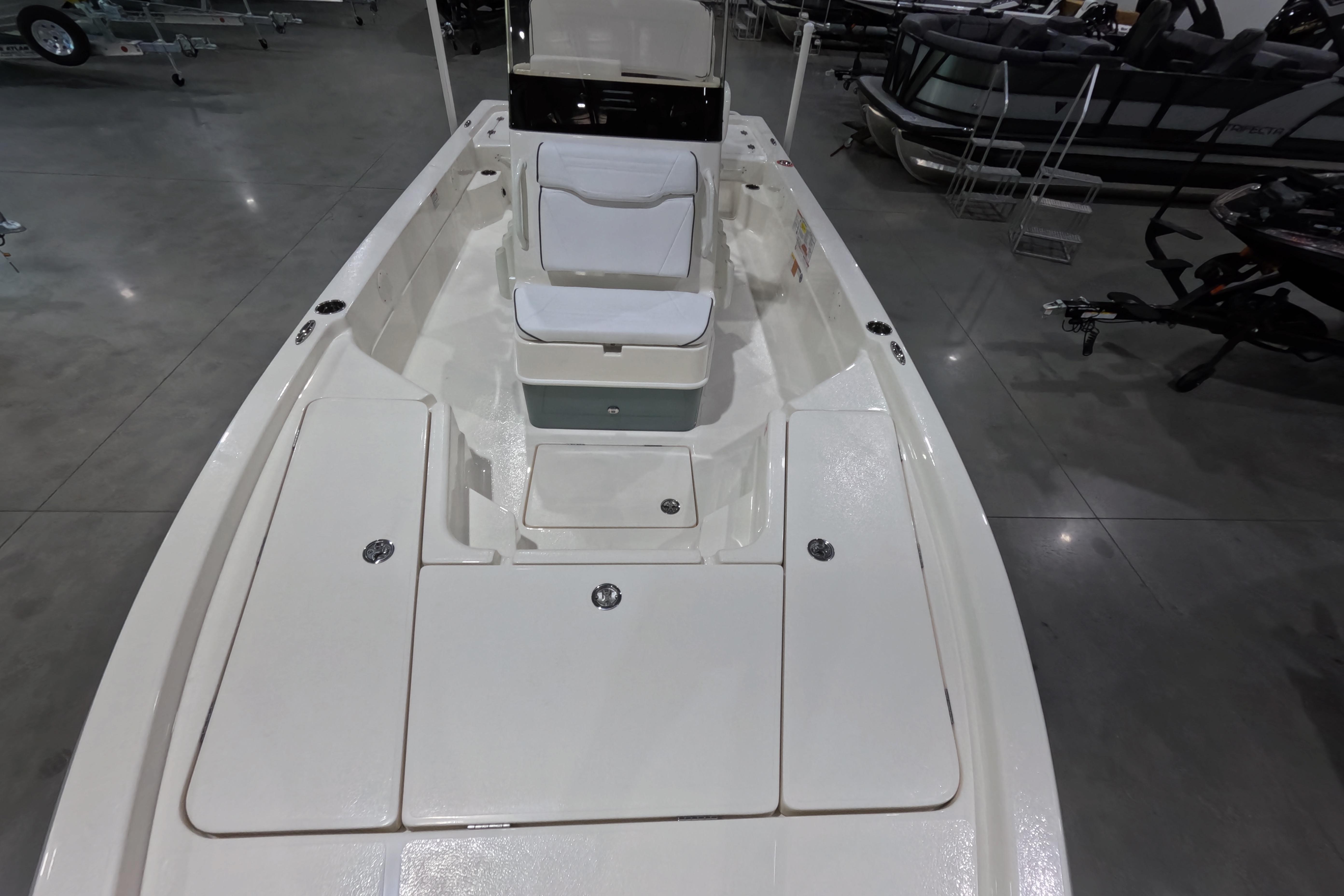 2026 Skeeter boat interior with white seating and storage compartments in showroom.