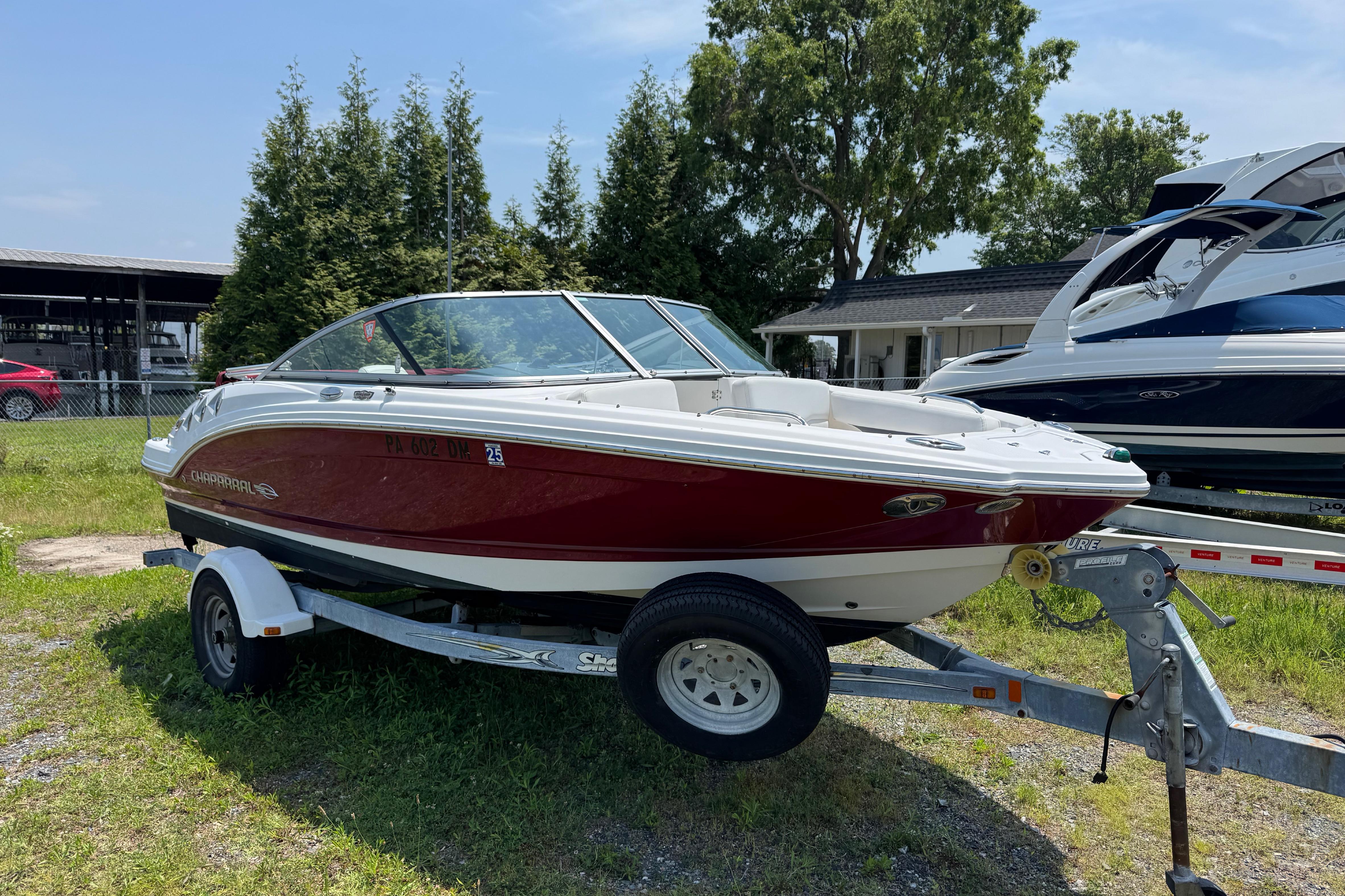 2013 Chaparral 196 SSi boat on trailer, parked outdoors on grass.