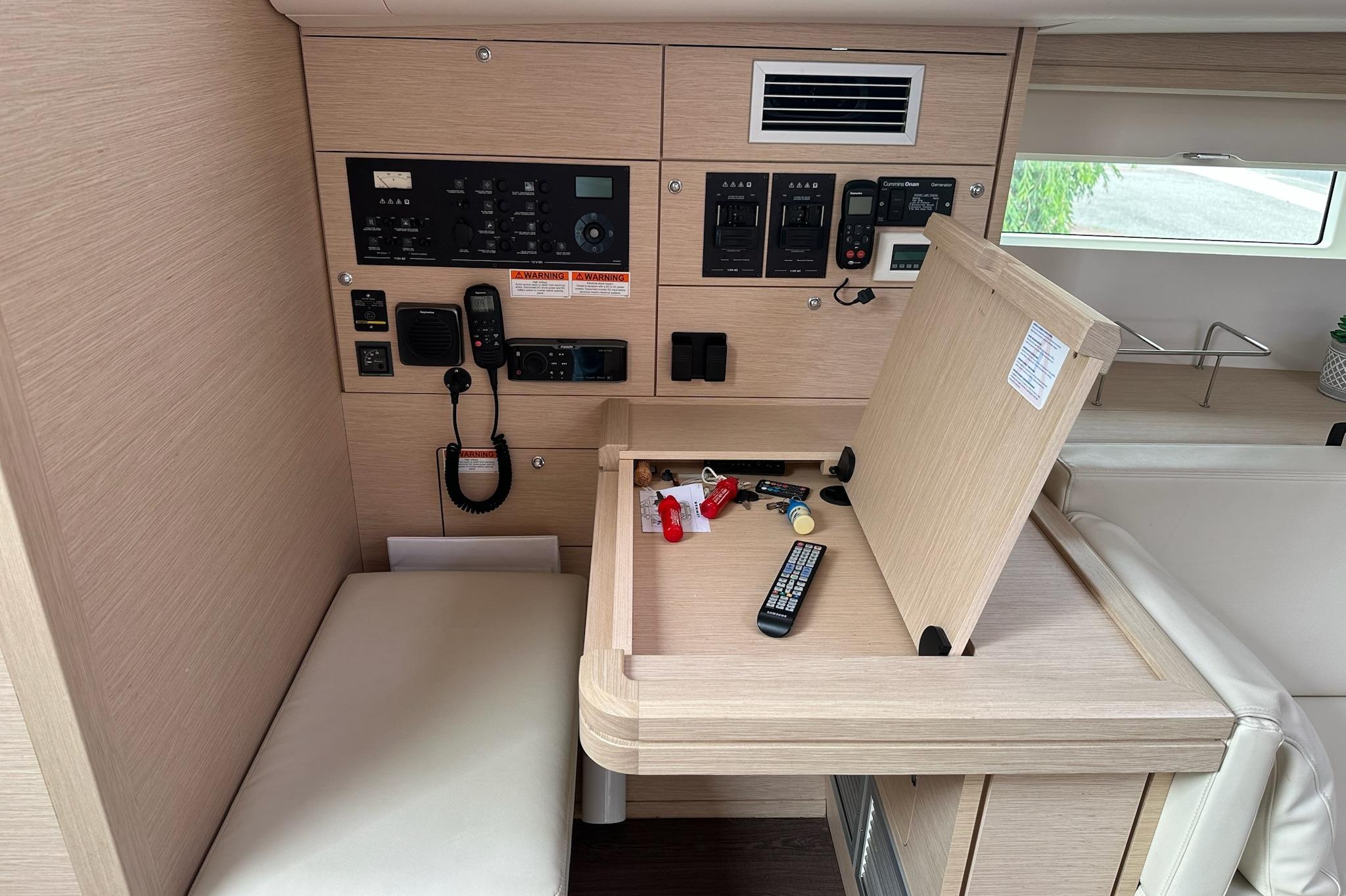 Control panel and seating area inside a 2018 Jeanneau 51 yacht, featuring navigation equipment.