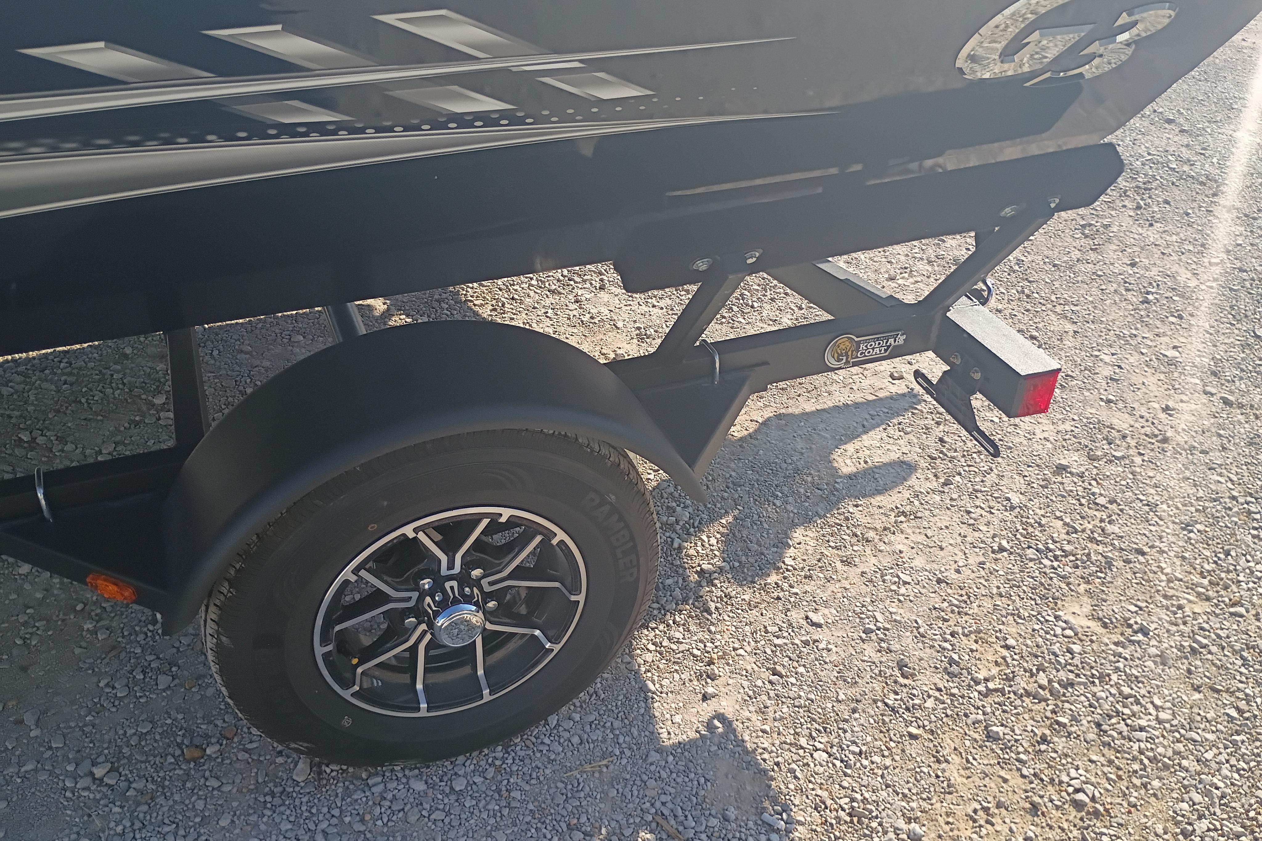 Trailer wheel and frame of 2026 G3 1810SE on gravel surface.