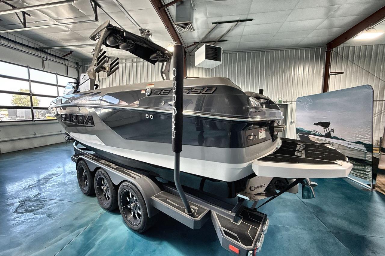 2021 Supra SE 550 boat on trailer in indoor showroom, showcasing sleek design and modern features.