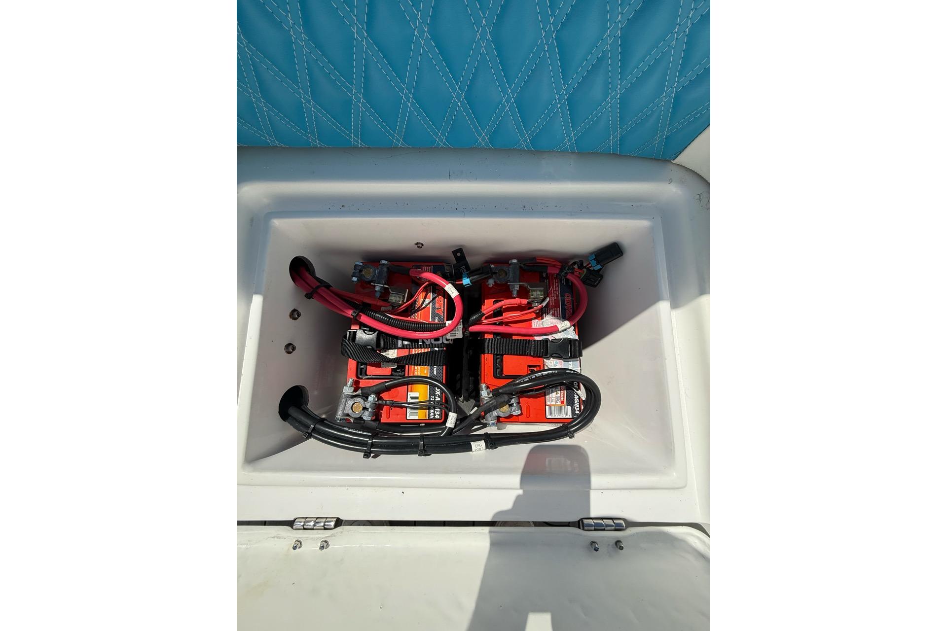 Battery compartment of 2021 Custom Infusion 34 CC boat with red and black cables.