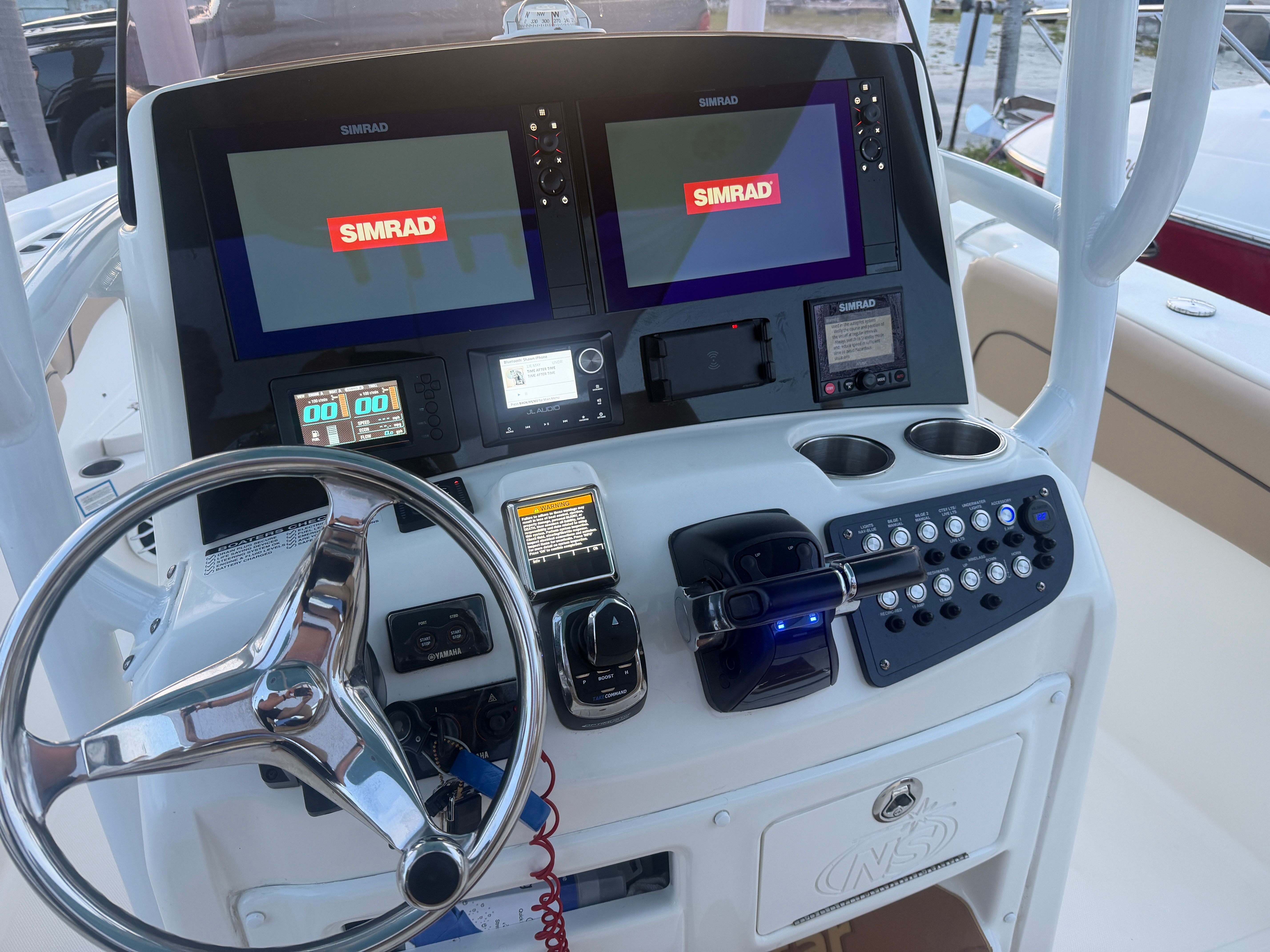 The image shows the helm of a 2019 NauticStar 28 XS with two Simrad screens.