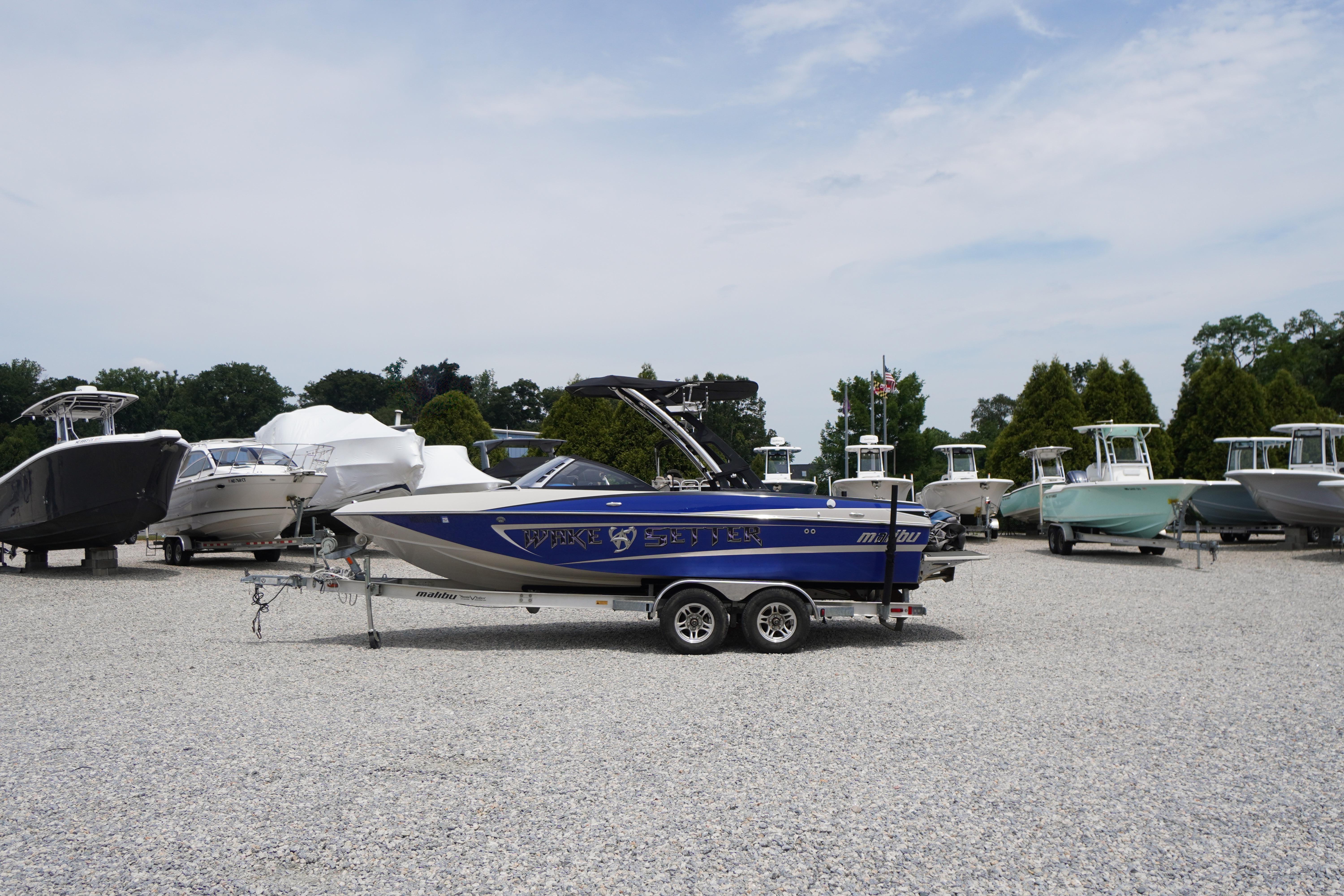 2011 Malibu Wakesetter 21 VLX boat on trailer in a boatyard.
