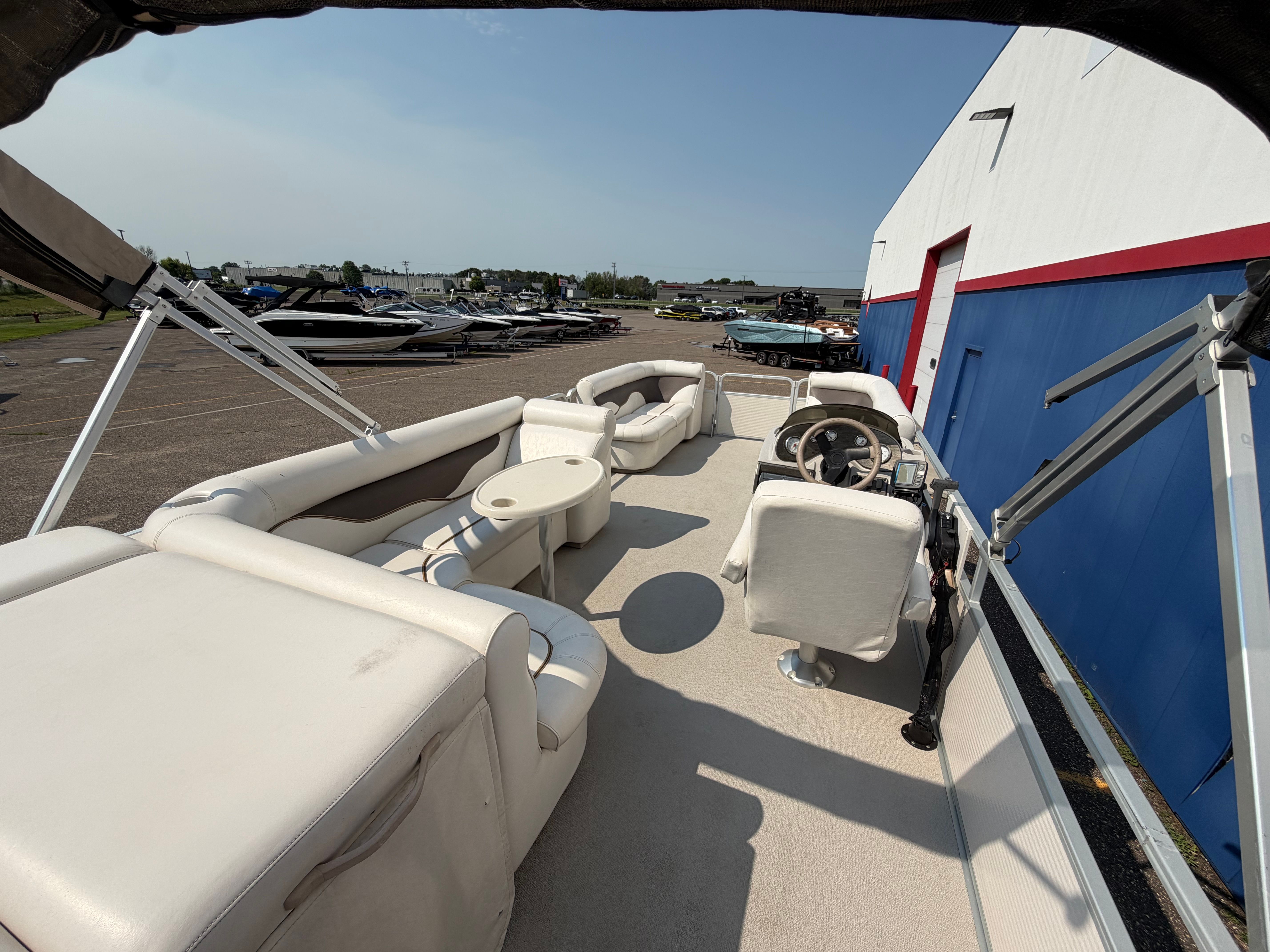 The image shows a 2007 Premier 225 Sunsation pontoon boat with white seating and a steering wheel.