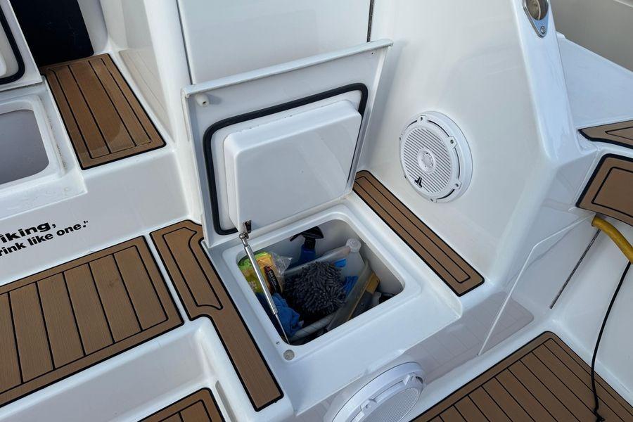 Storage compartment on 2002 Viking 61 Enclosed Bridge yacht, featuring cleaning supplies and teak flooring.