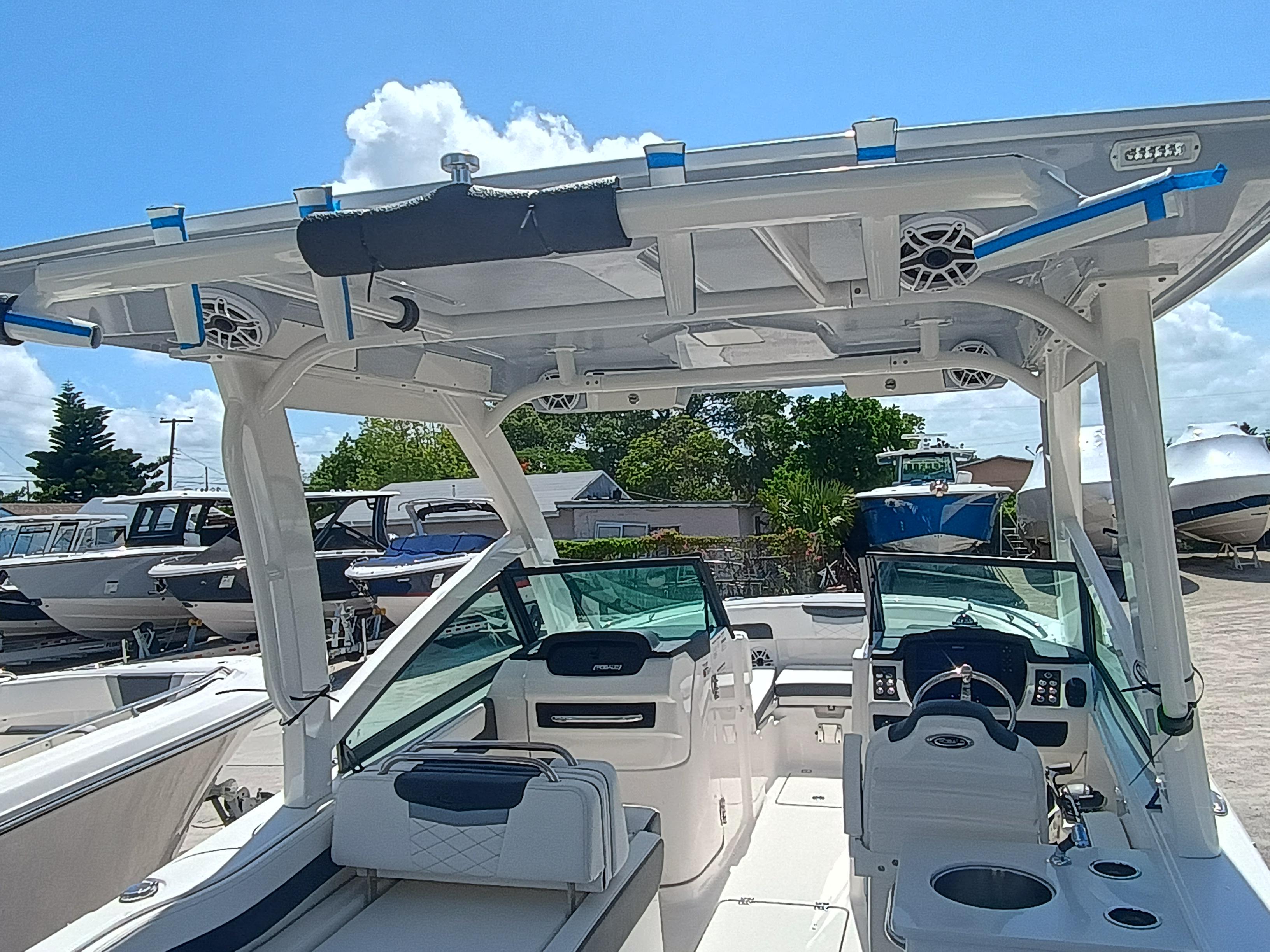 2025 Robalo R257 Dual Console boat interior with seating and helm, under a clear blue sky.