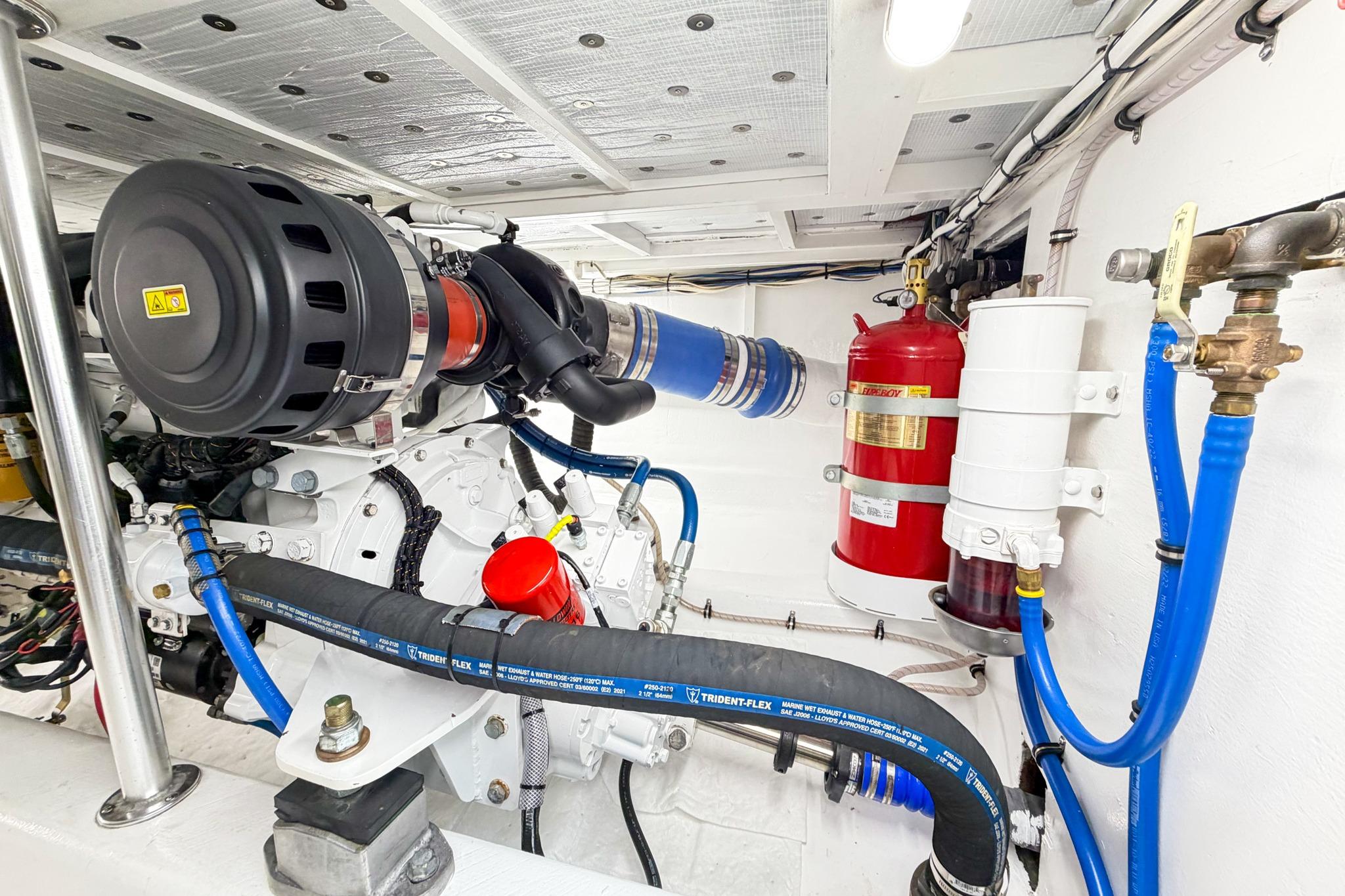 Engine room of 1998 Blackwell Custom Carolina Sportfish with visible hoses and fire extinguisher.