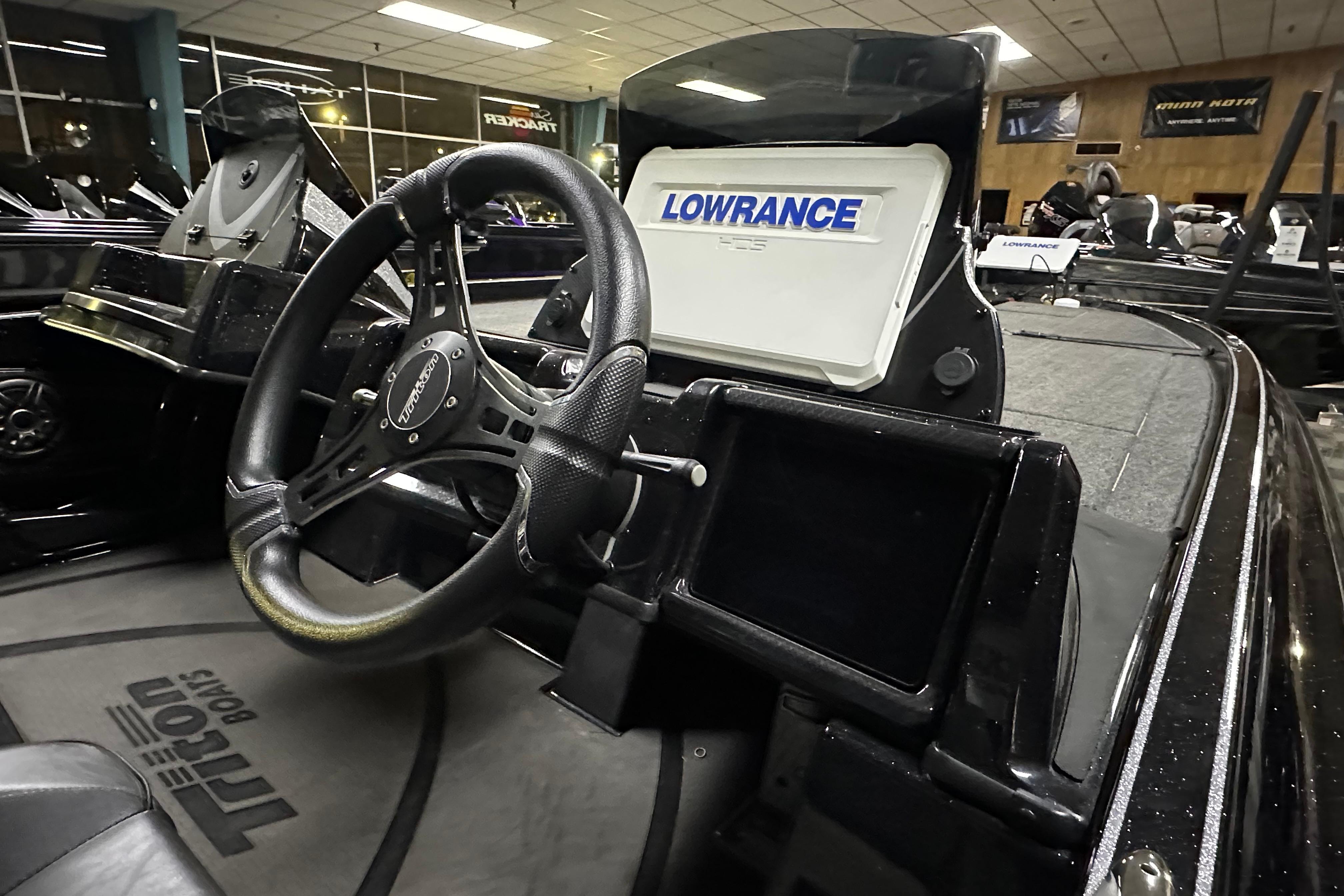 Interior of 2025 Triton 21XP Patriot boat with steering wheel and Lowrance display.