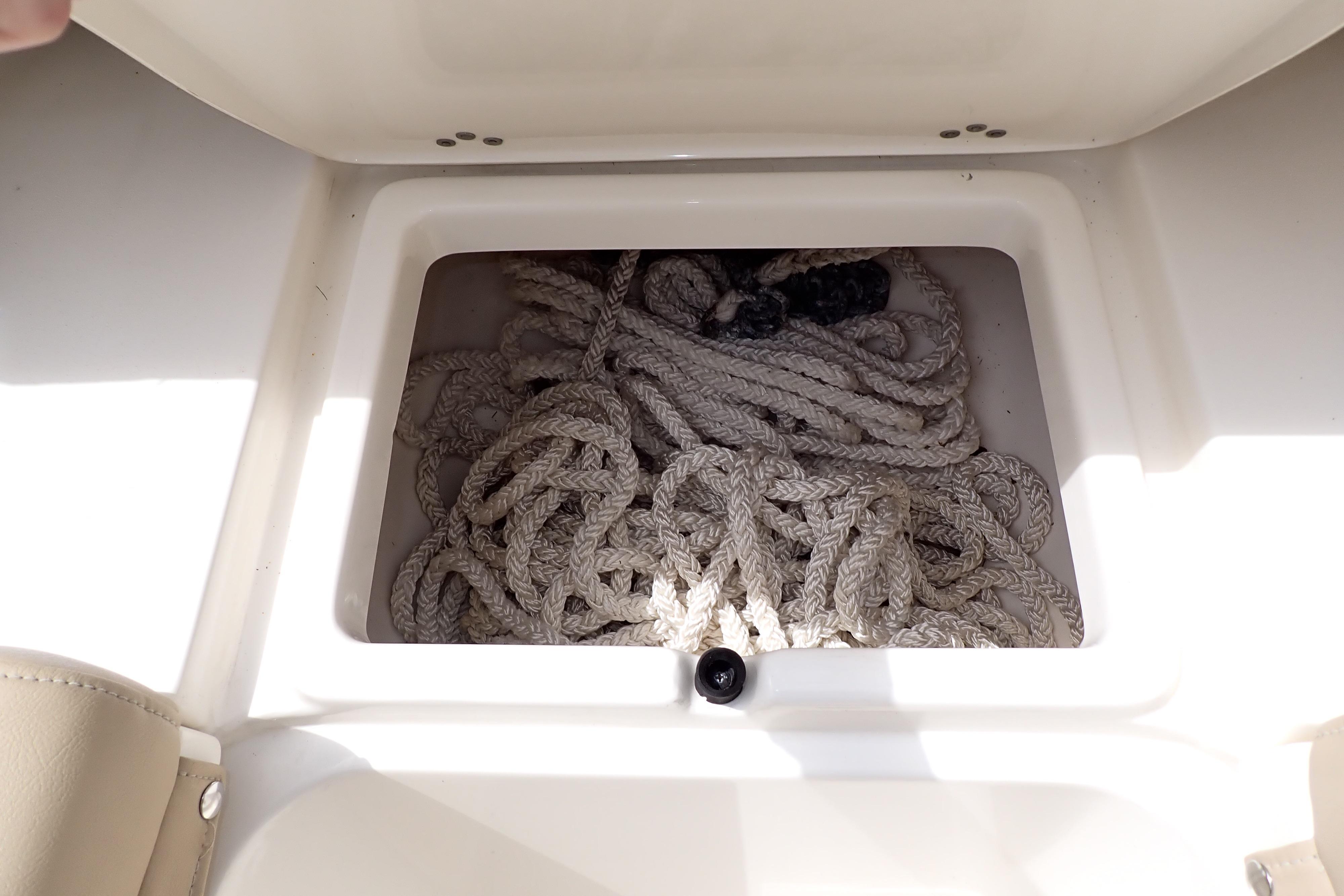 Storage compartment with coiled rope on a 2019 Key West 263 FS boat.