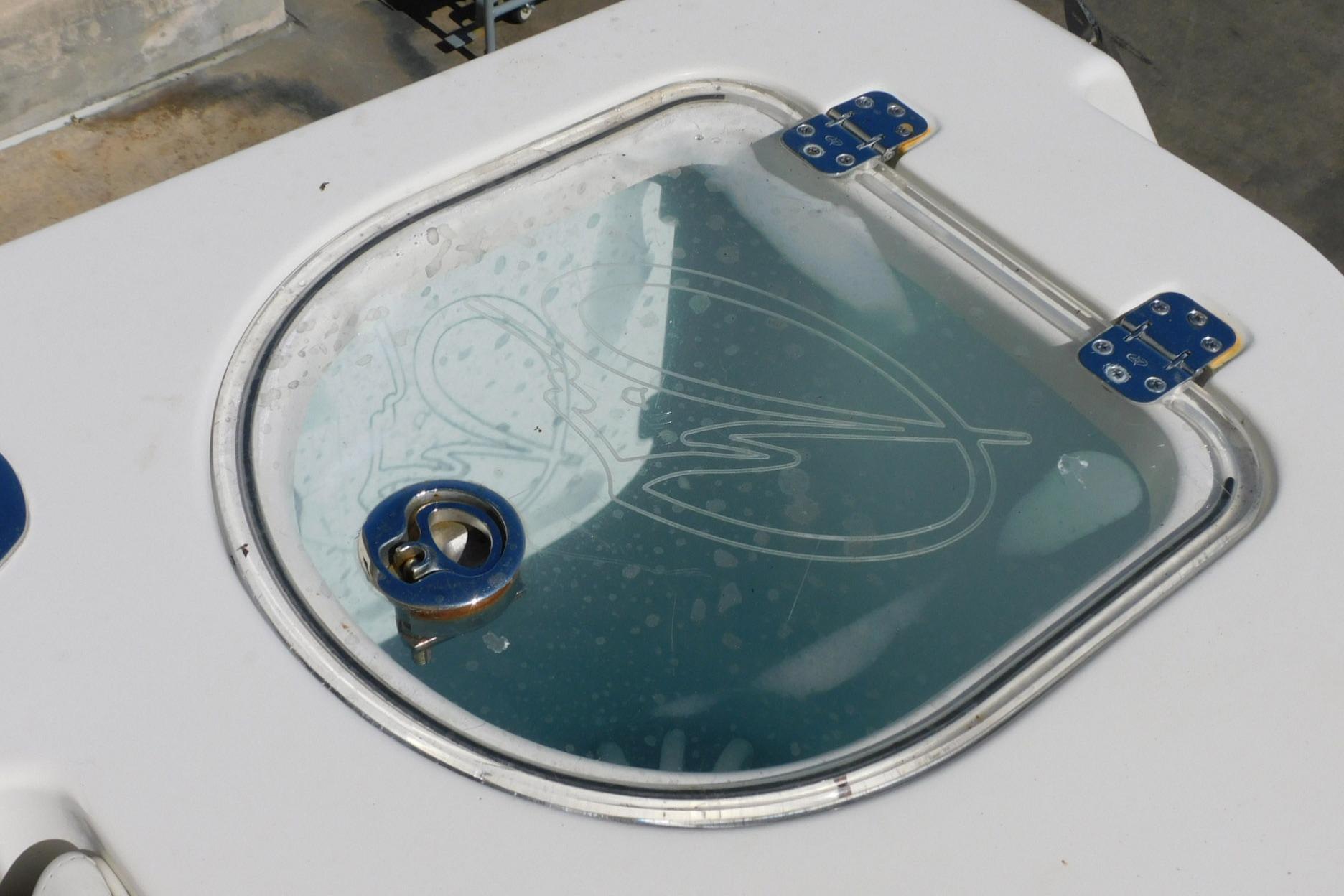 Livewell lid on a 2012 Sailfish 30-06 Express boat, featuring a clear top and blue hinges.