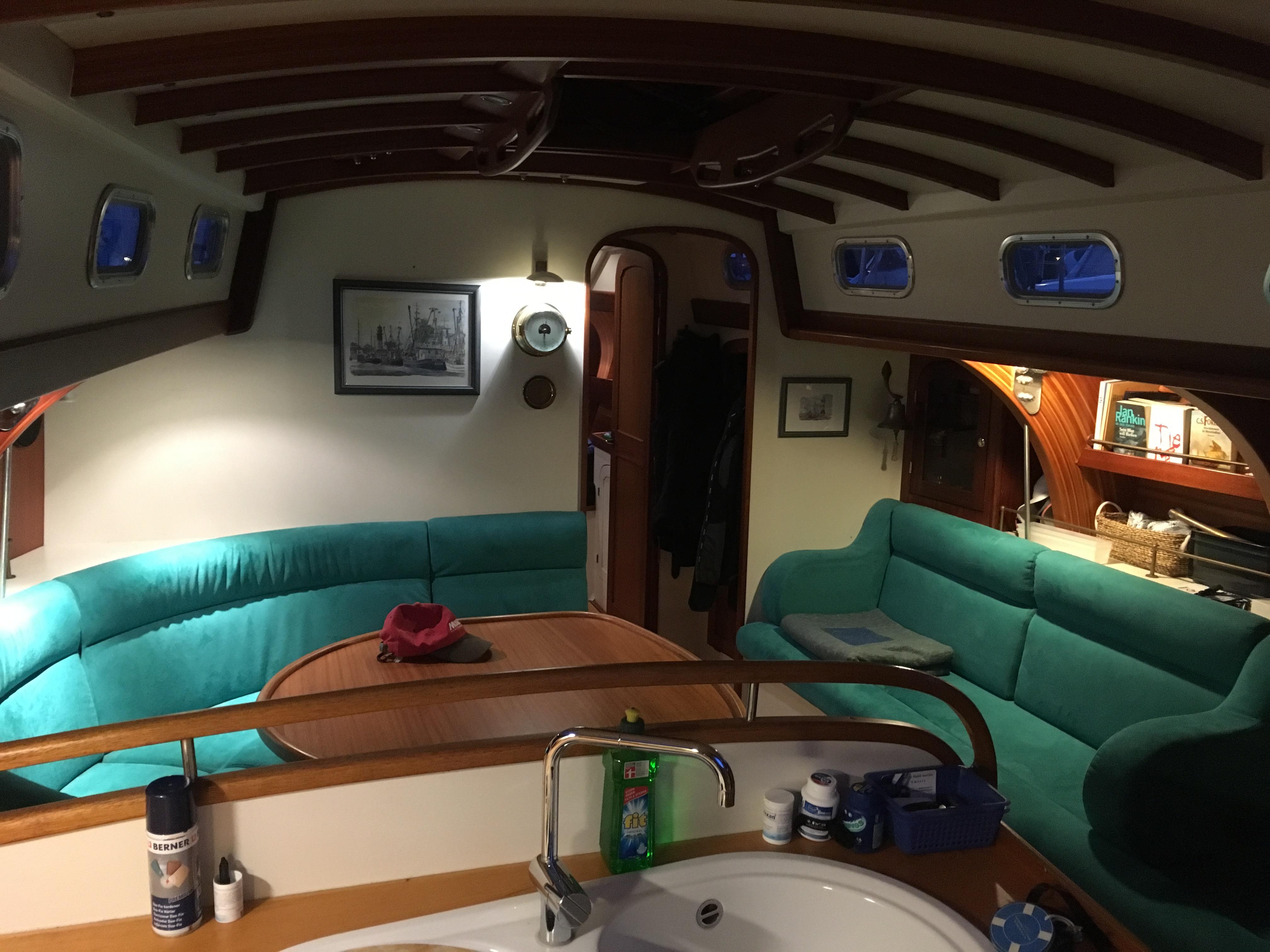Interior of a 1998 Custom Ravell 42 yacht with teal seating and wooden accents.