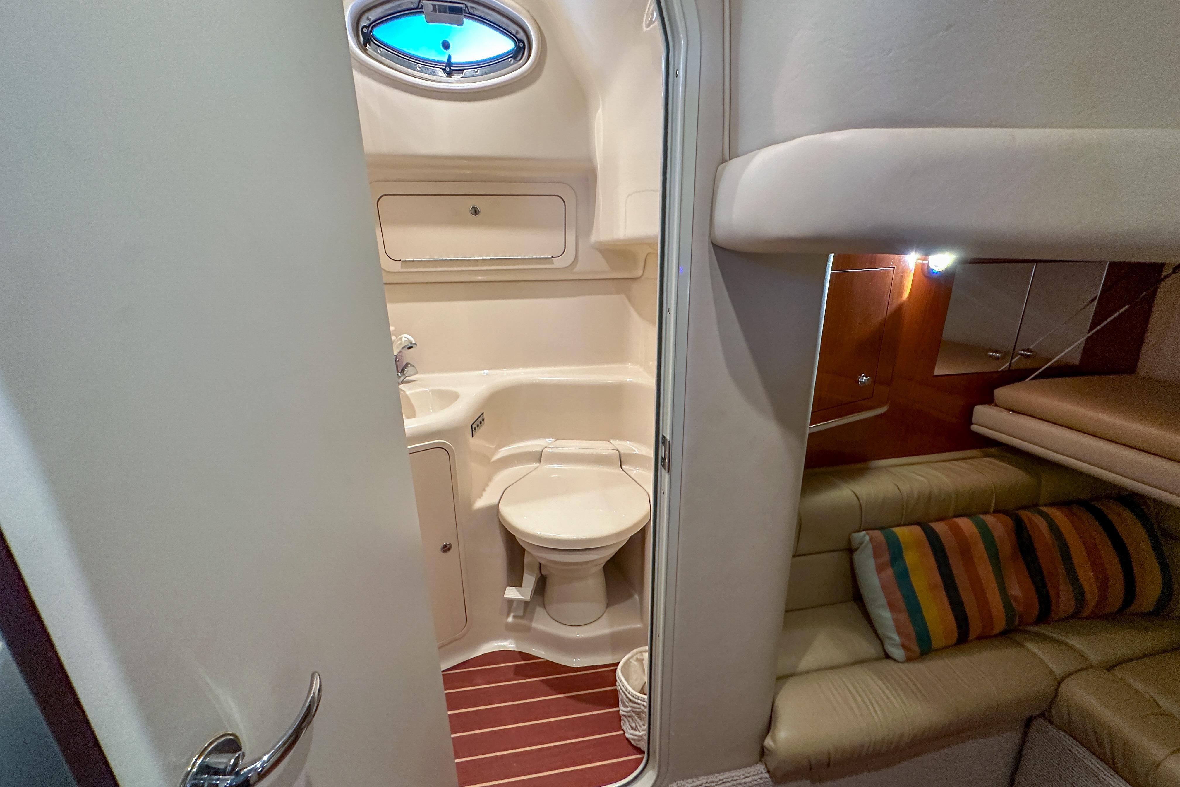 2001 Sea Ray 410 Sundancer yacht interior with bathroom and cozy seating area.