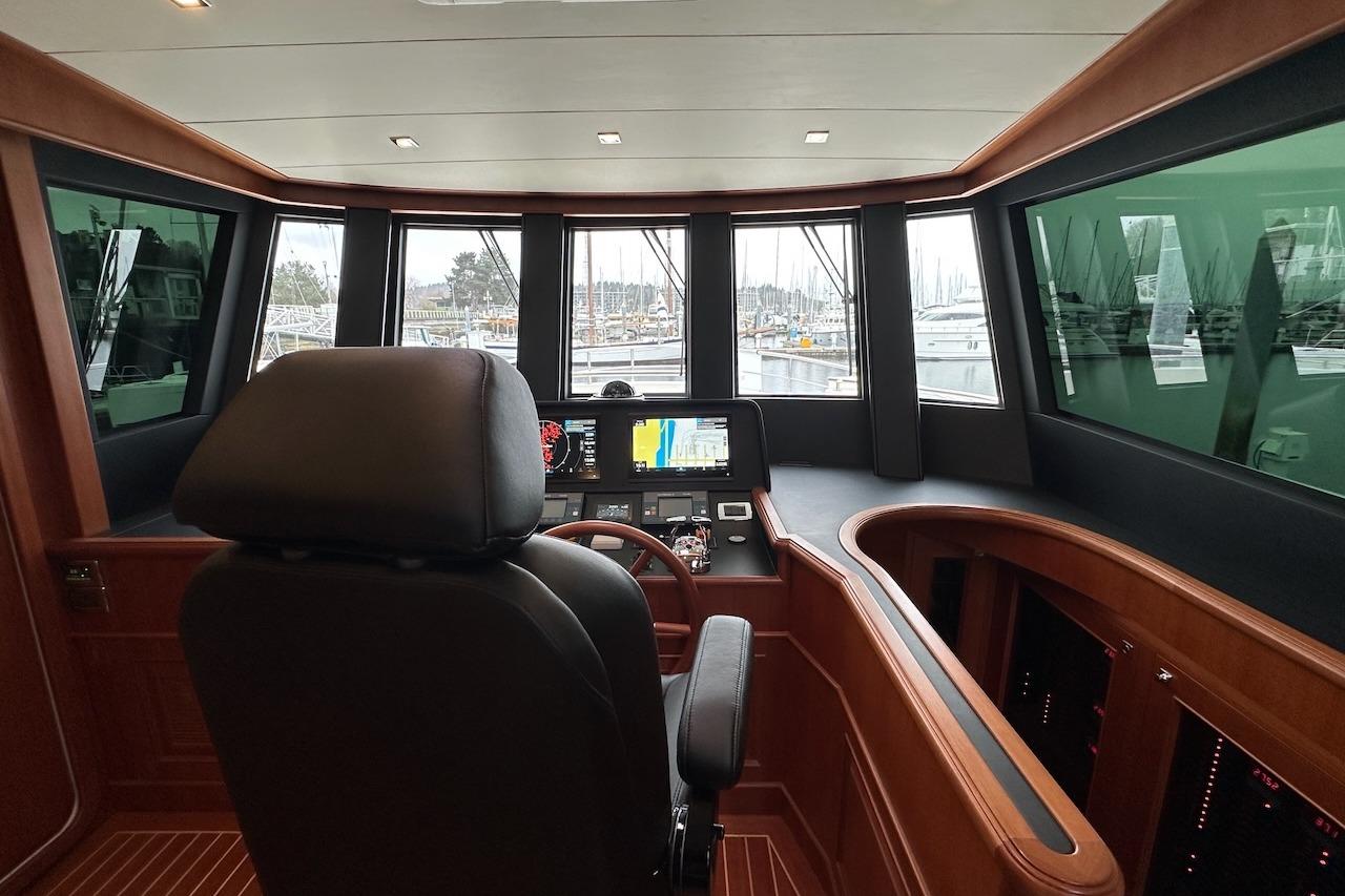 Pilothouse interior of 2024 Northwest 55 yacht, featuring modern navigation equipment and panoramic windows.