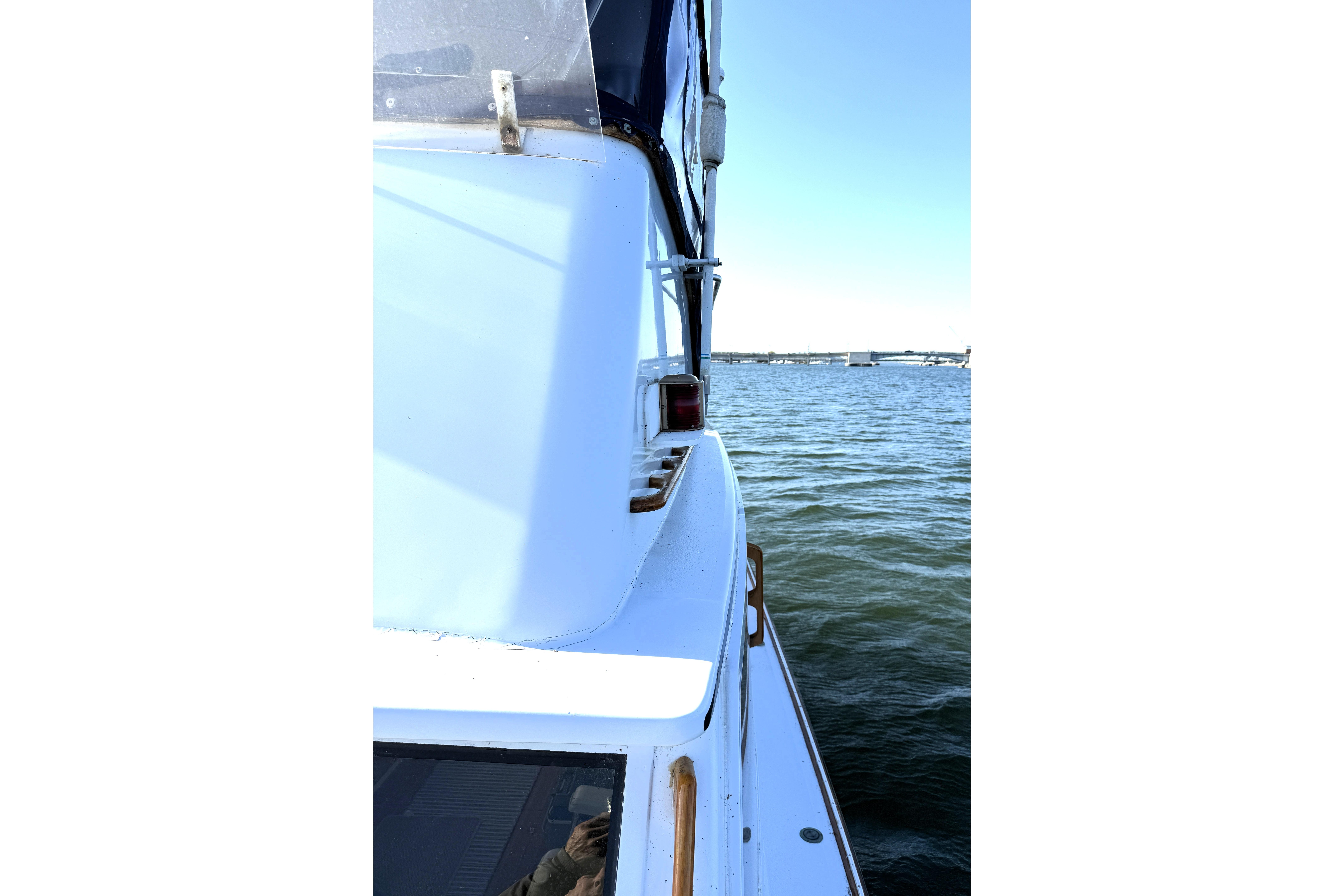1983 Wilbur 34 Fly Bridge Cruiser on calm water, side view.