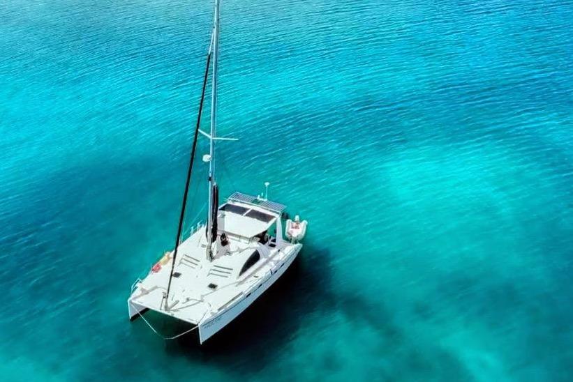 Aerial view of a 2001 Robertson & Caine Leopard catamaran on clear turquoise water.