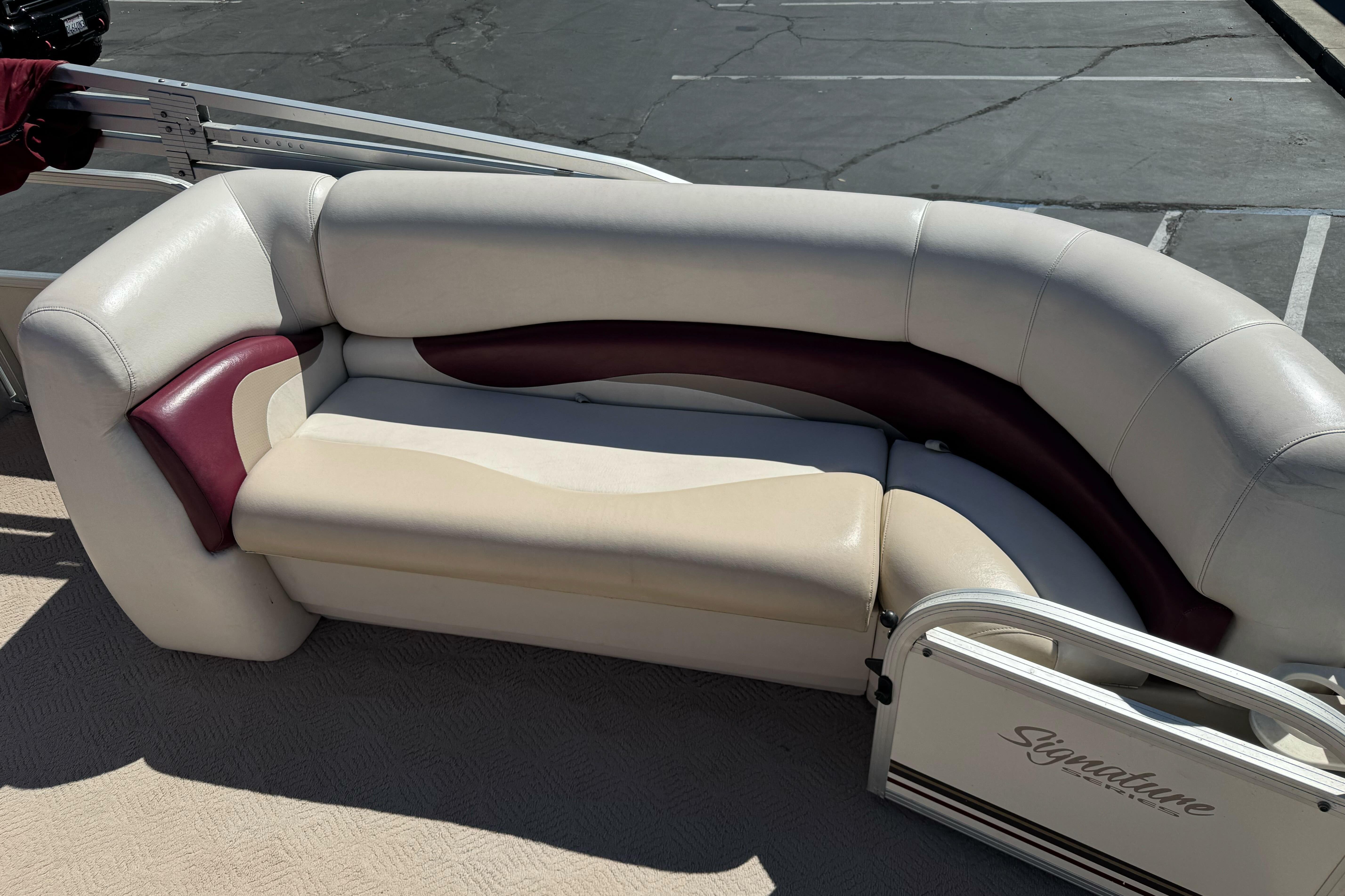 2011 Sun Tracker Party Barge 21 seating area with beige and maroon upholstery.