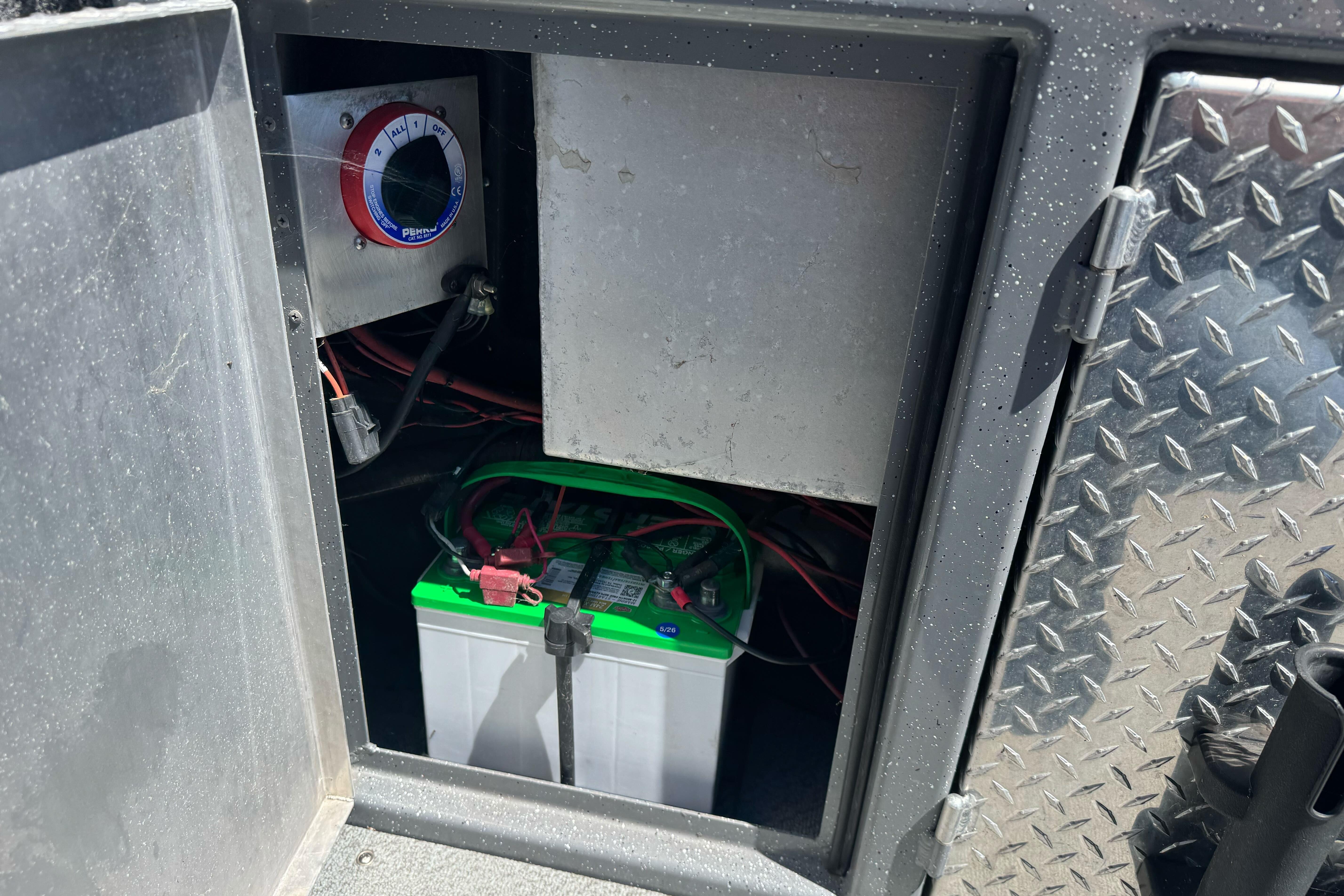 Battery compartment of a 2014 River Hawk 19 GB boat with wiring and control panel.