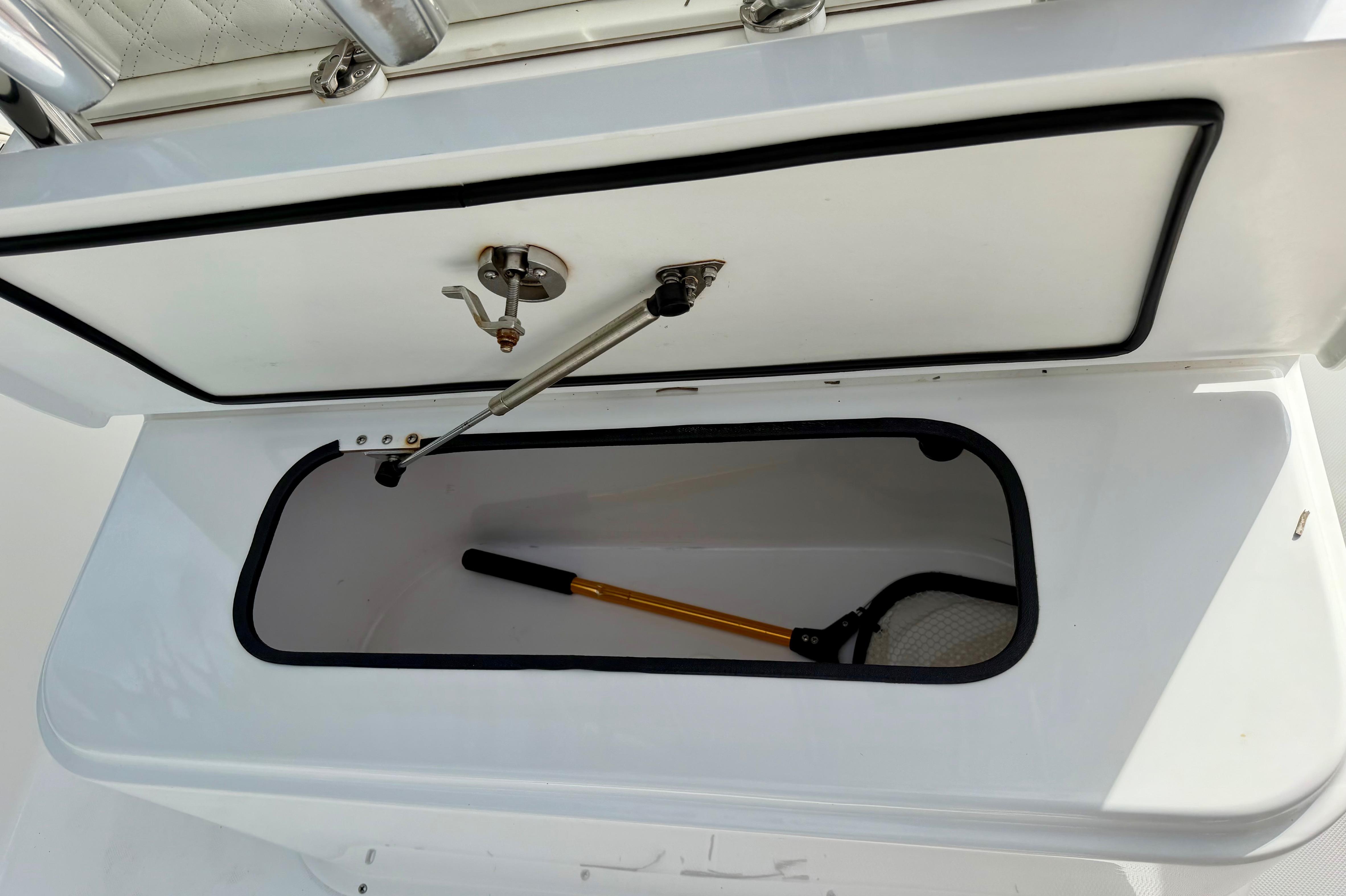 Storage compartment on 2025 Ocean Master 296 Center Console boat, featuring a fishing net.