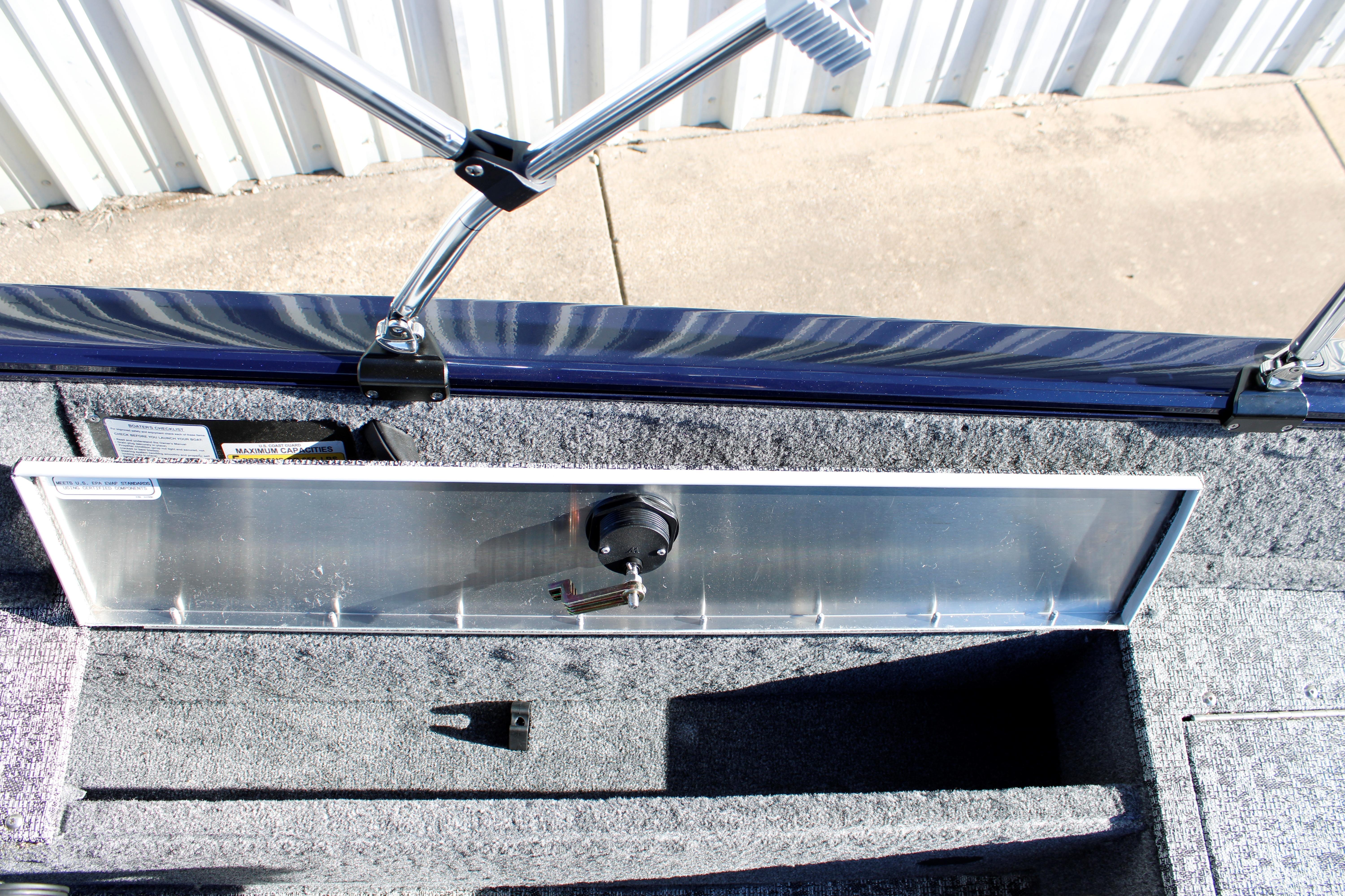 Interior view of 2026 Tracker Pro Guide V-16 SC boat, showcasing storage compartment and latch mechanism.