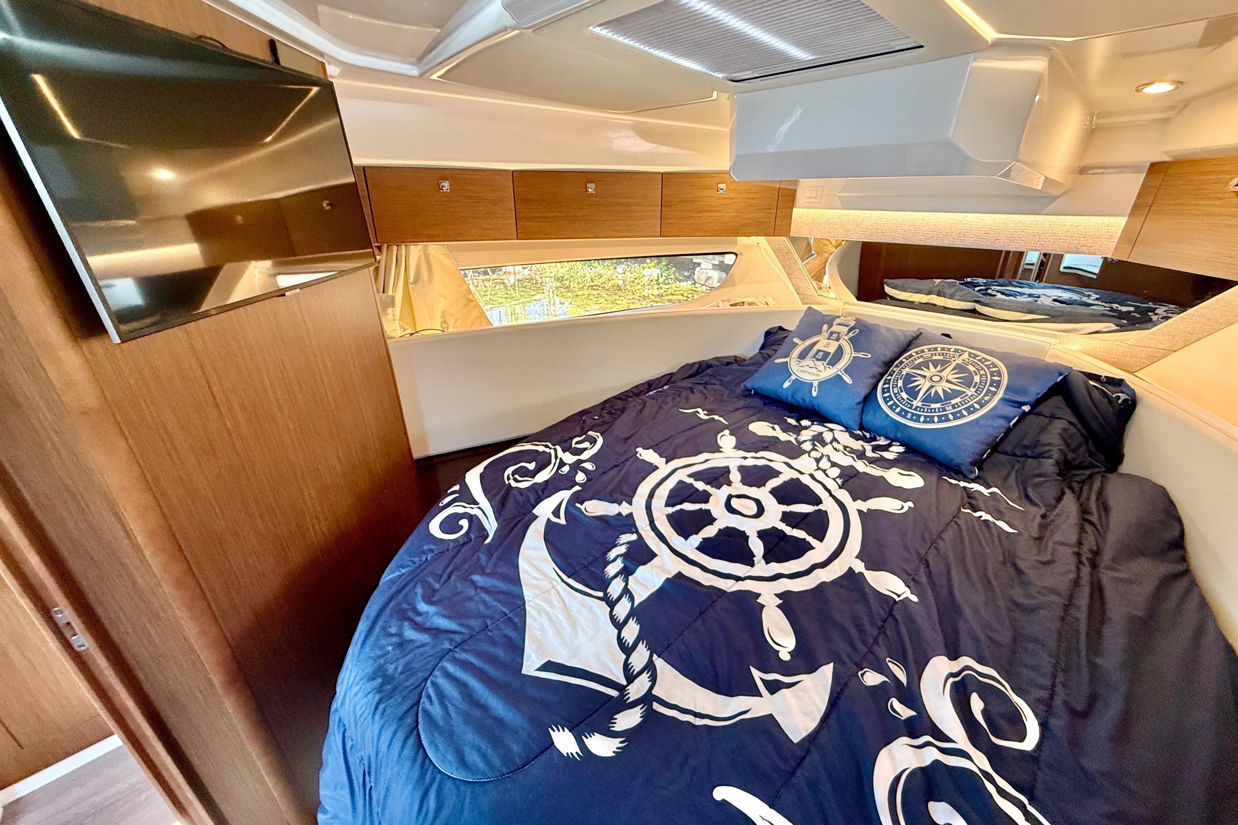 Luxurious cabin interior of 2022 Jeanneau NC 1095 Fly with nautical-themed bedding.