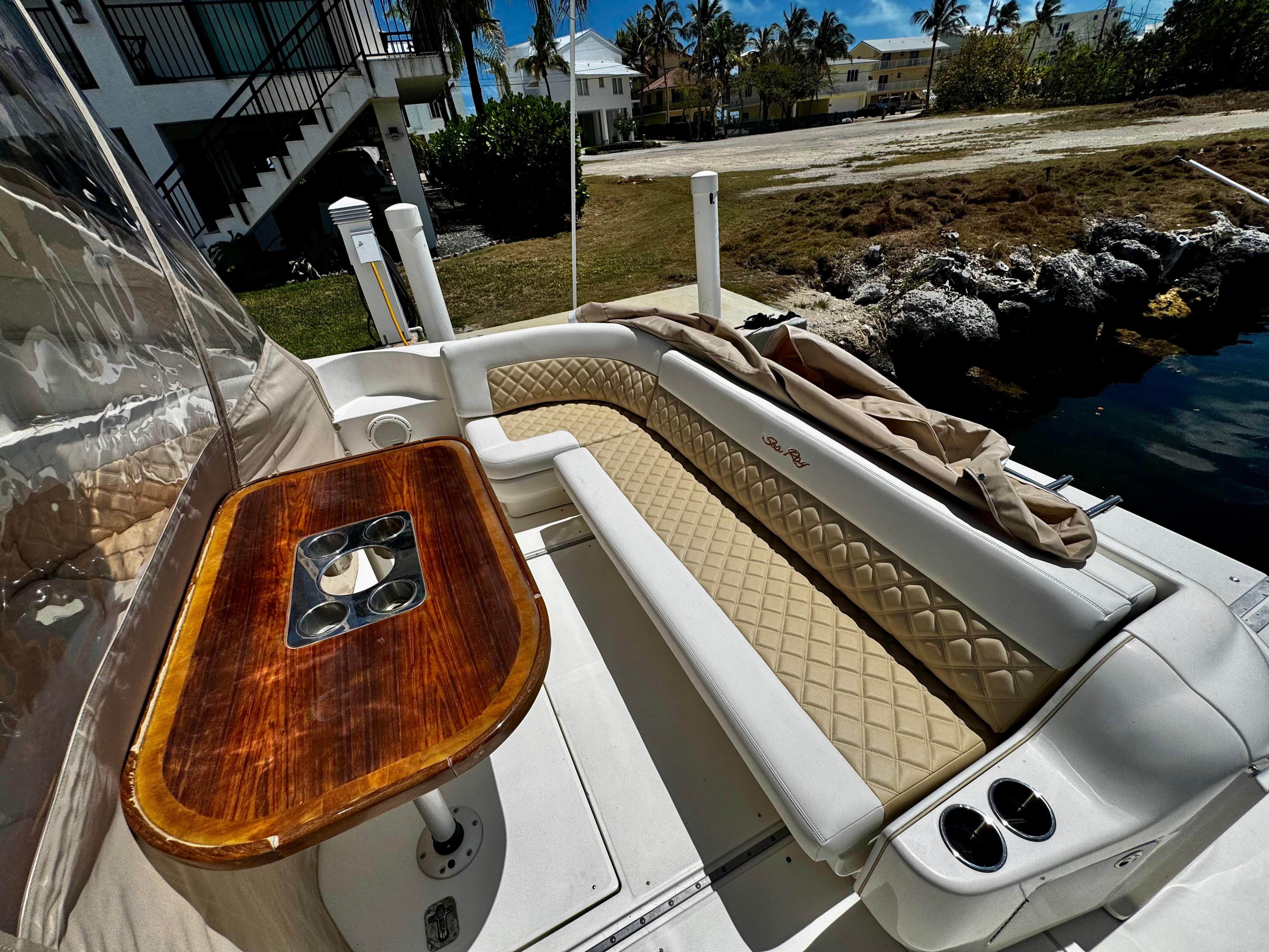 2001 Sea Ray 460 Sundancer boat interior with cushioned seating and wooden table.