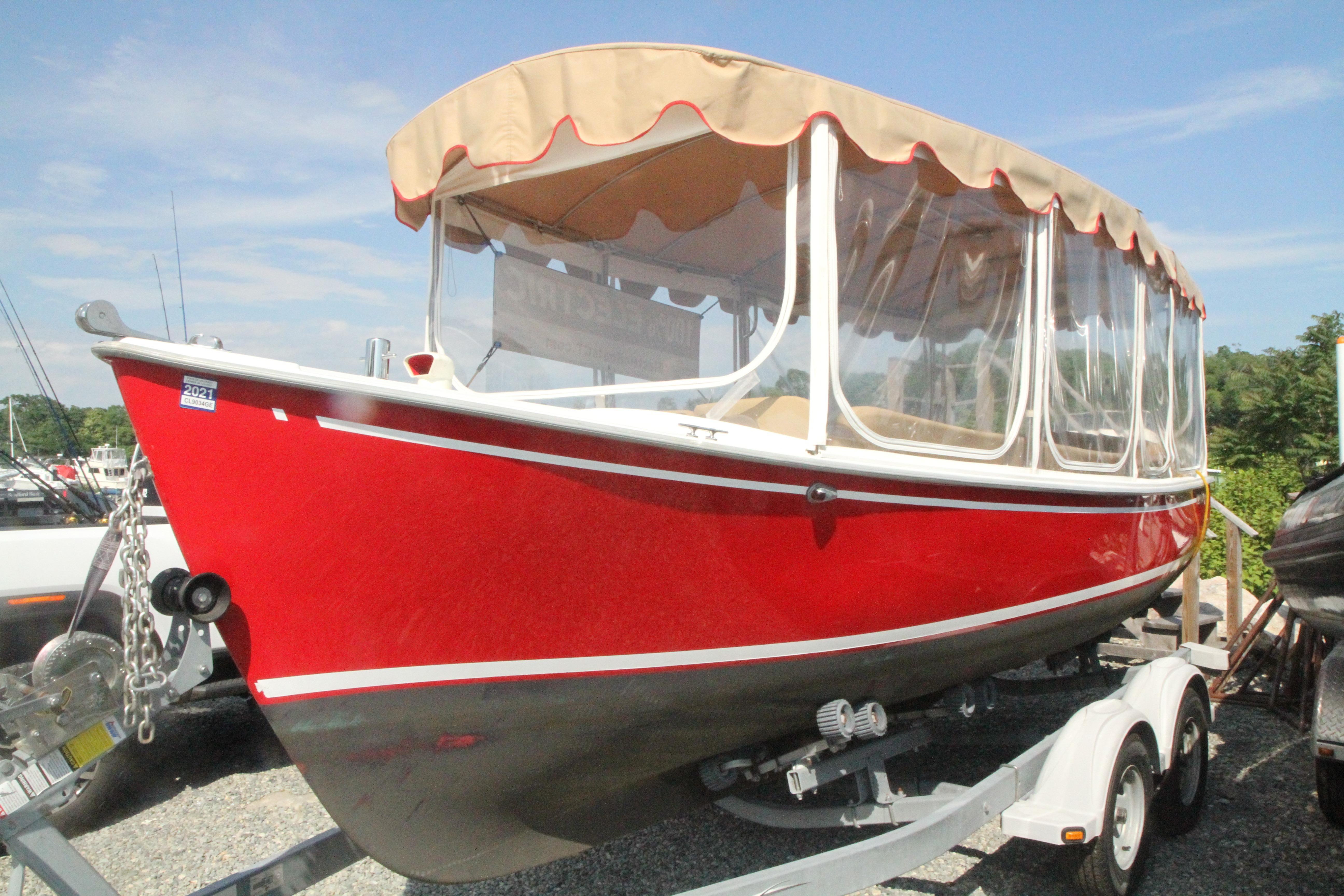 Red 2004 Duffy 21 Classic boat on trailer, with beige canopy and clear side panels.