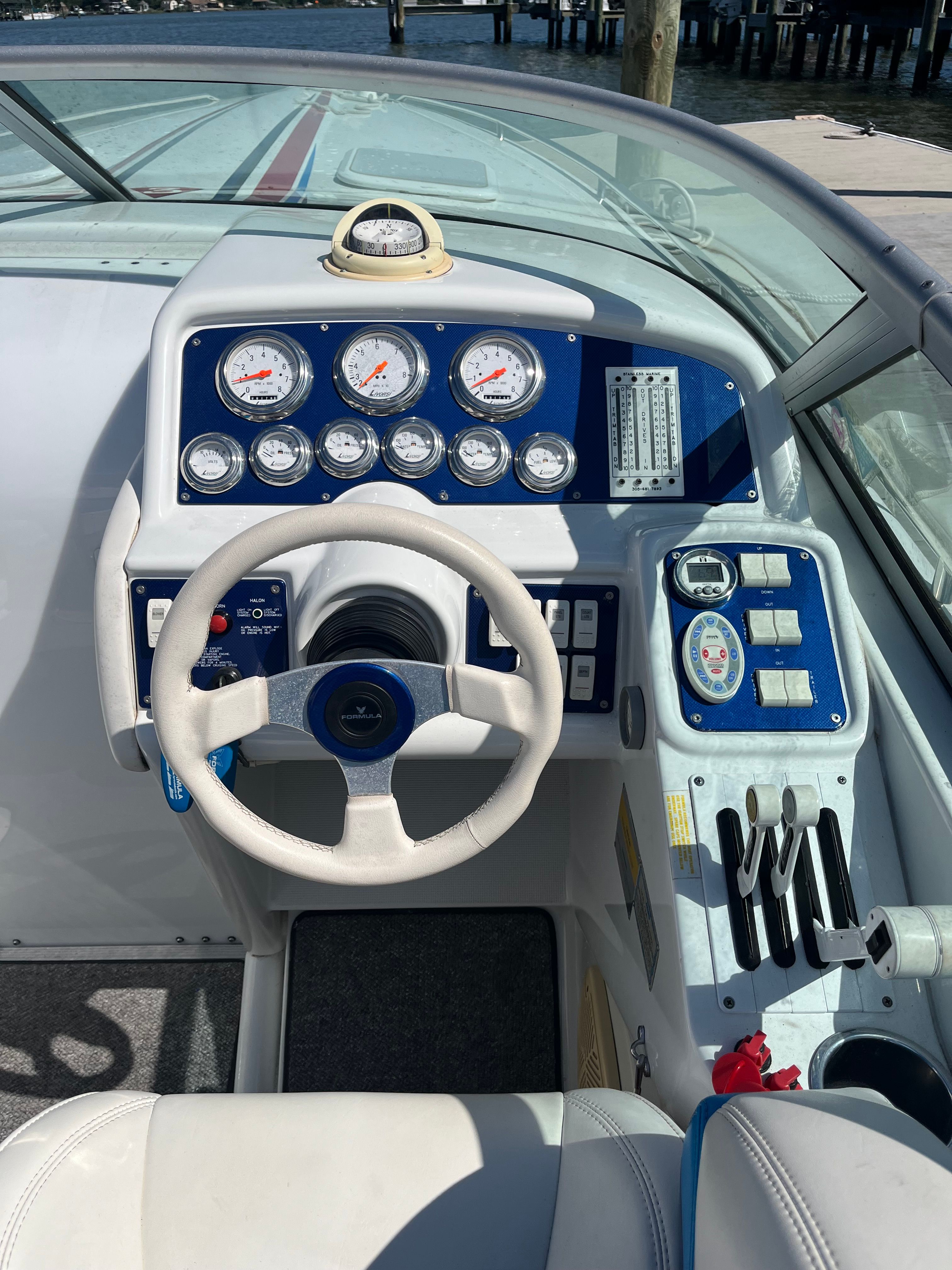 The cockpit of a 2004 Formula 292 FASTech with a white steering wheel and blue instruments.