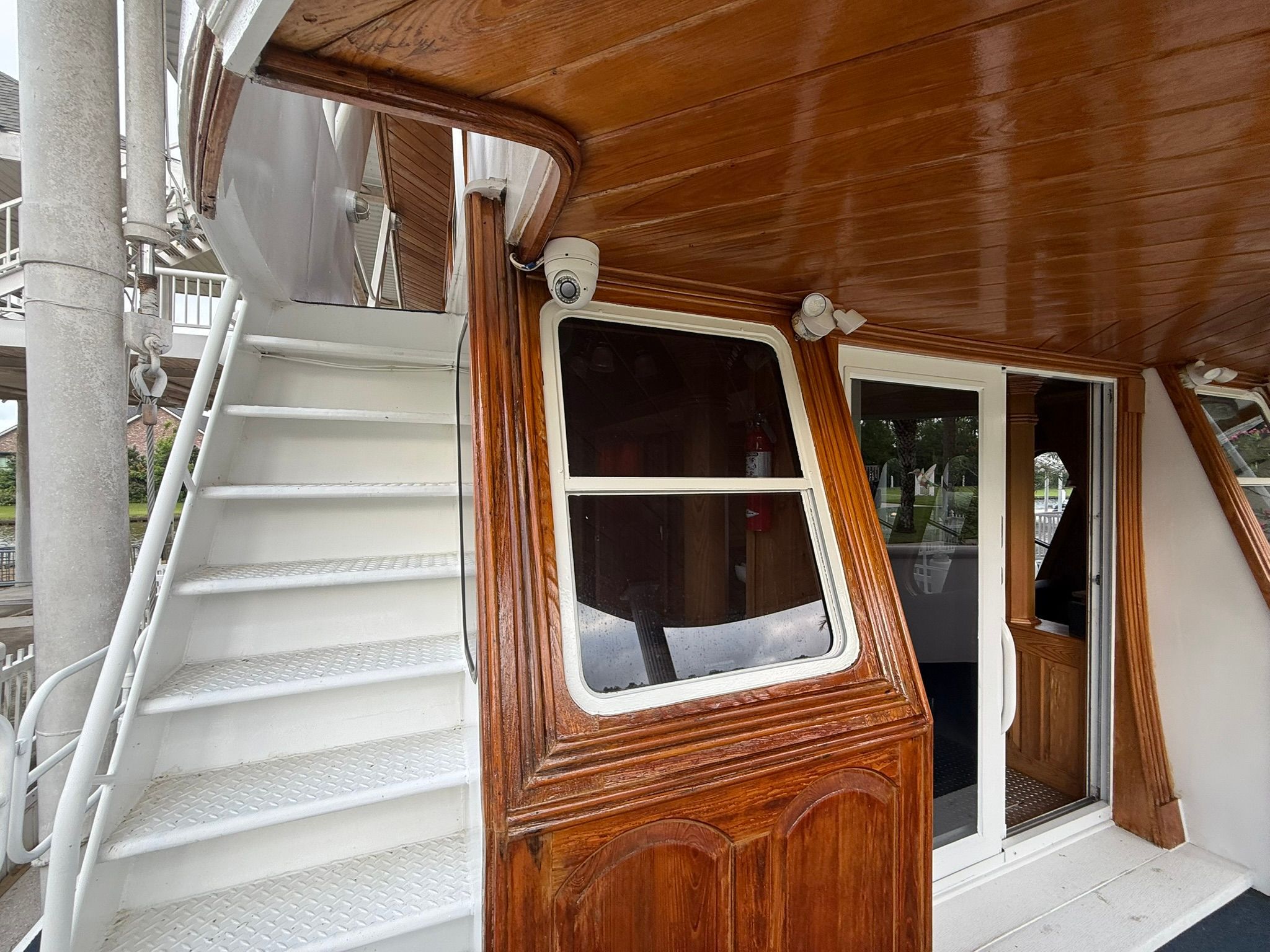 Wood-paneled boat with white stairs and windows, creating a cozy atmosphere.