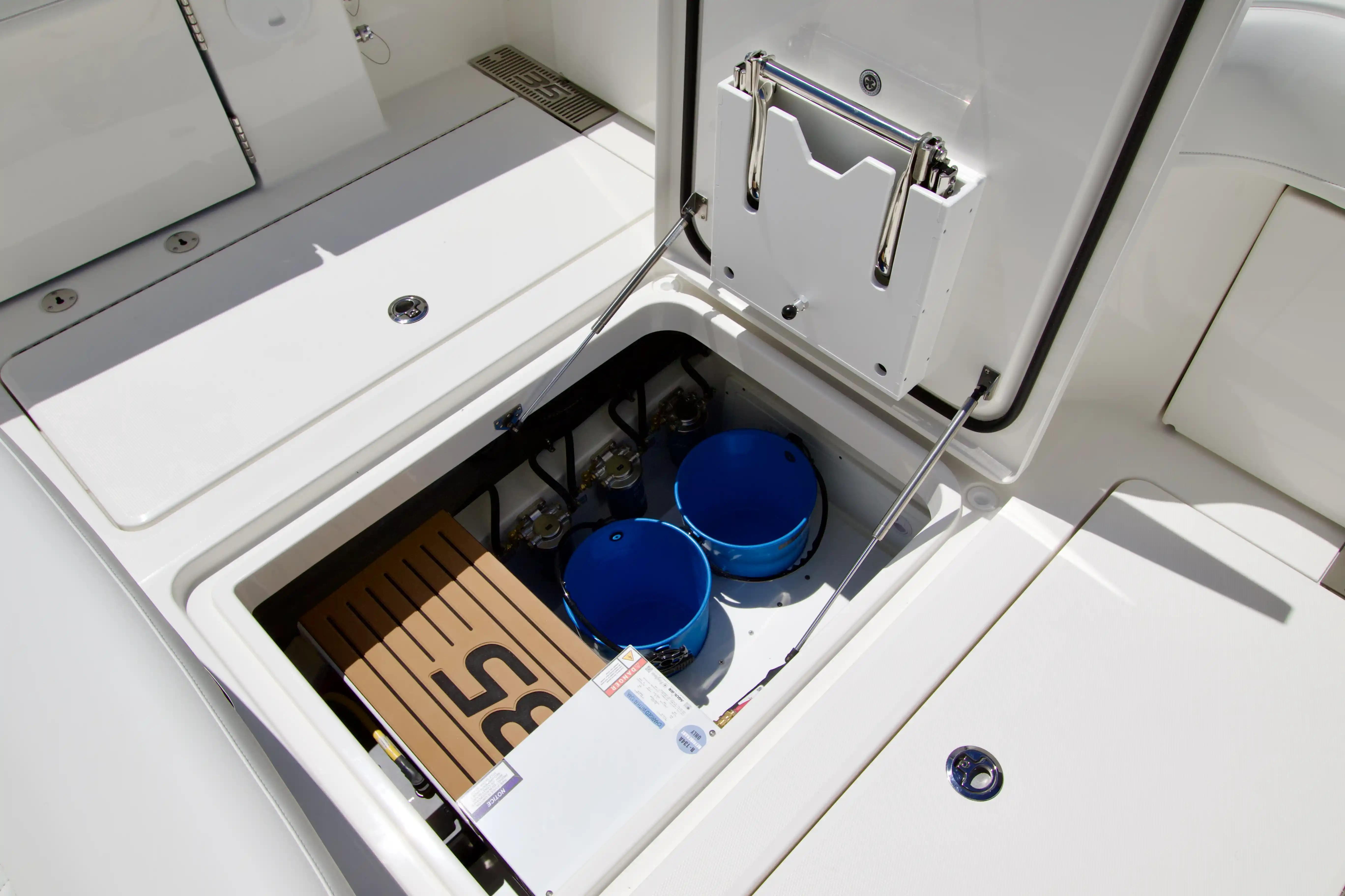 Storage compartment of 2027 Regulator 35 boat with blue buckets and equipment.