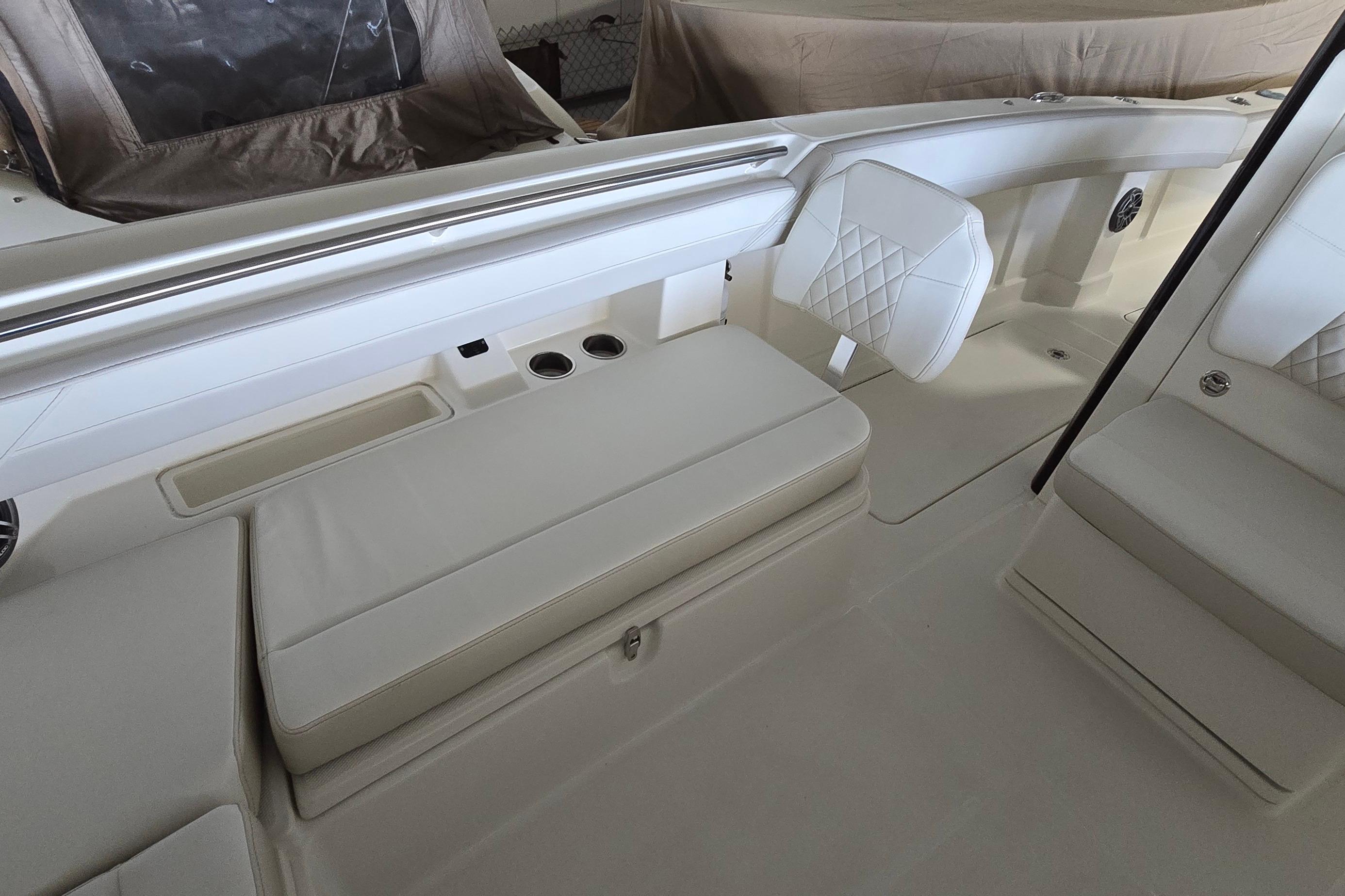 2024 WorldCat 280 CC-X boat interior with white cushioned seating and cup holders.