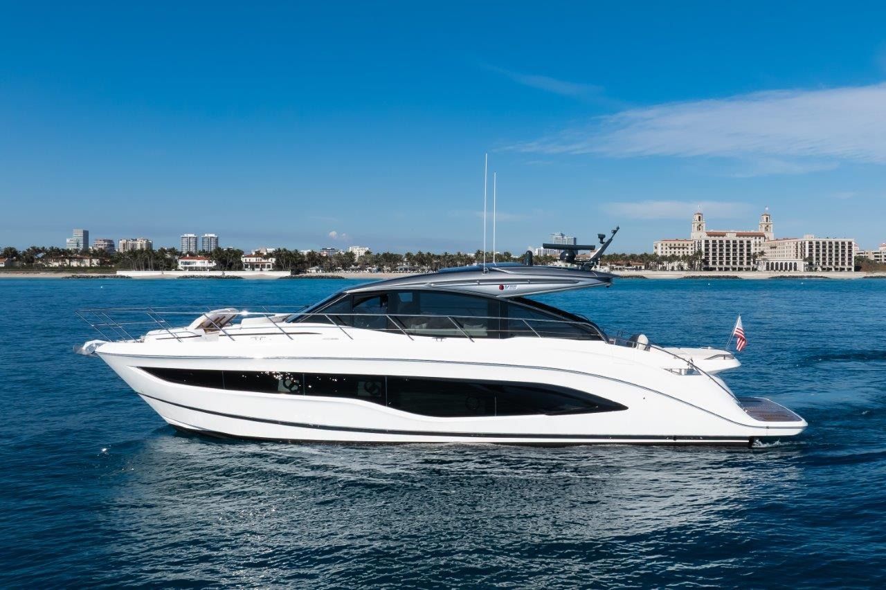 The 2025 Princess V55 is a sleek motor yacht on calm waters, featuring a modern silhouette.