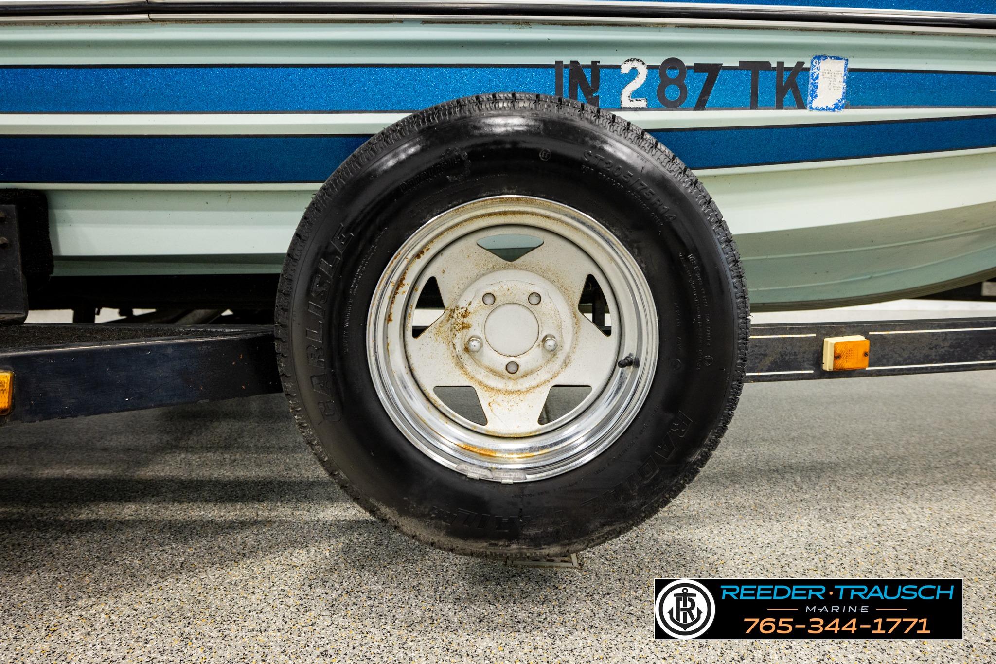 1980 Ranger 175 VS boat trailer tire with visible license number and dealership logo.
